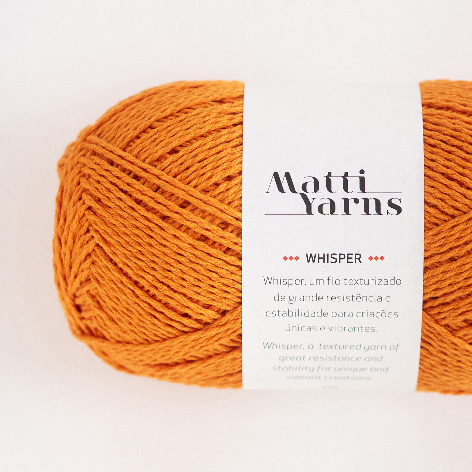 Novelo de fio laranja com rótulo da marca Matti Yarns