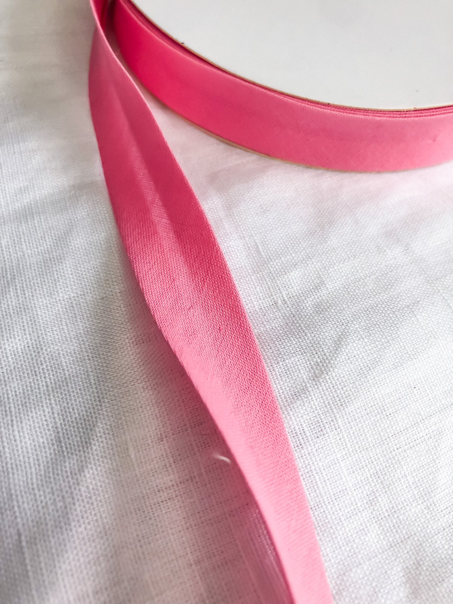 Fita de cetim rosa sobre tecido branco