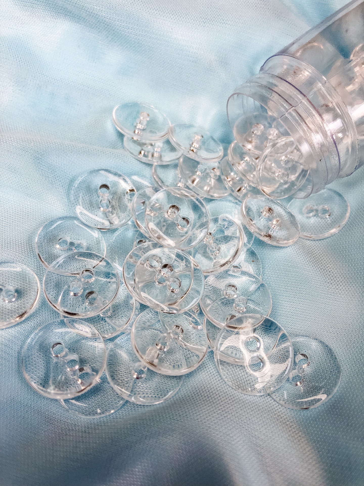 Botões redondos transparentes sobre tecido azul claro