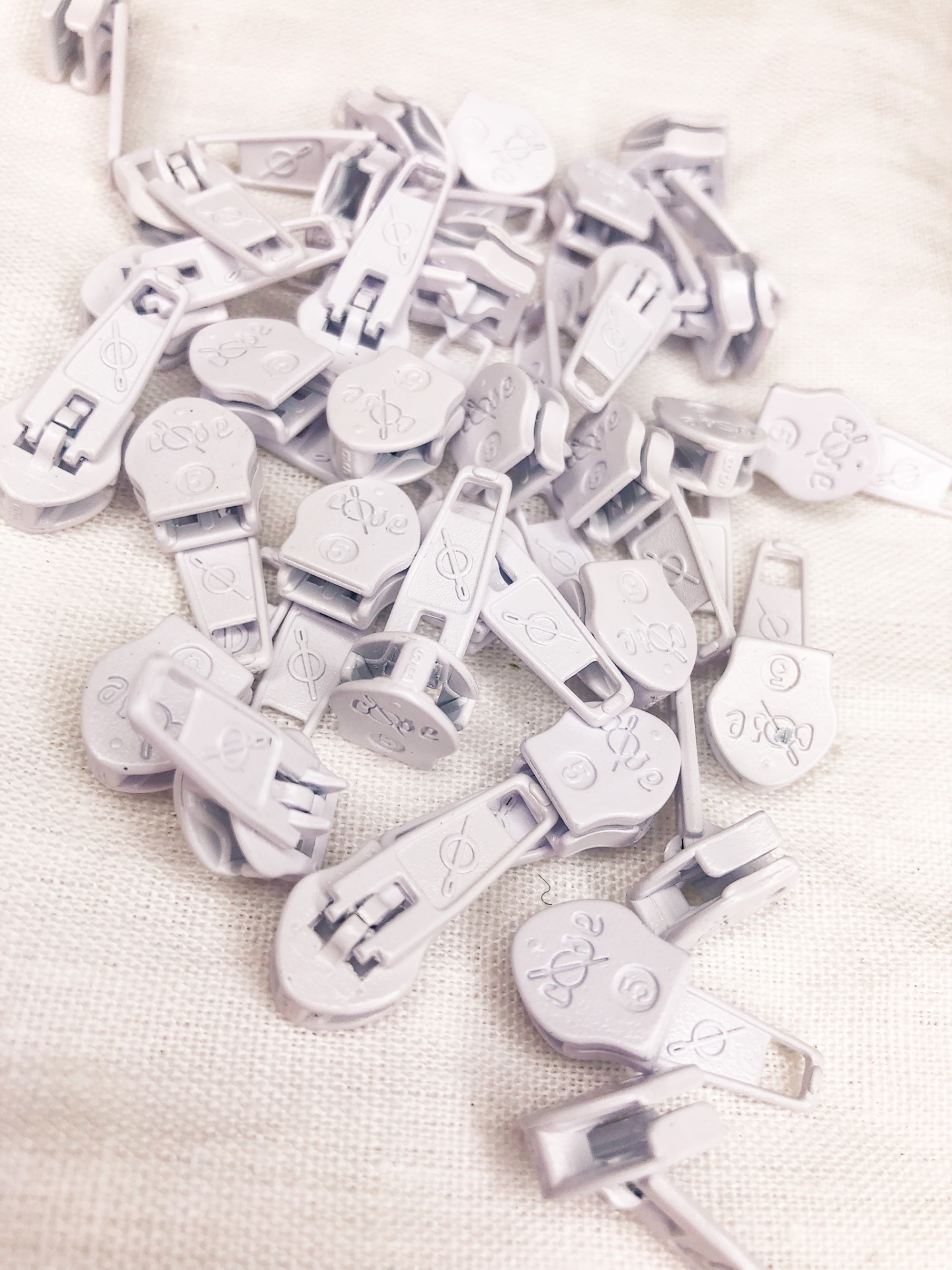 Fechos de correr brancos de plástico sobre tecido bege claro