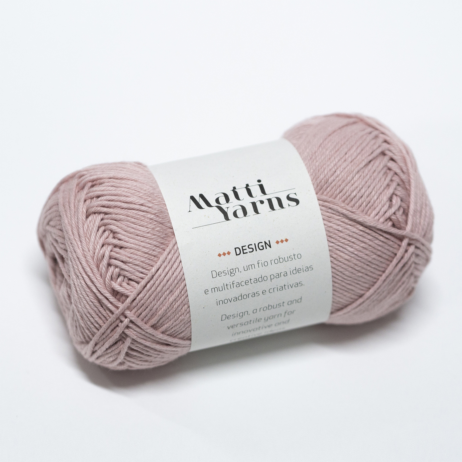 Novelo de fio rosa claro com etiqueta 'Matti Yarns DESIGN'
