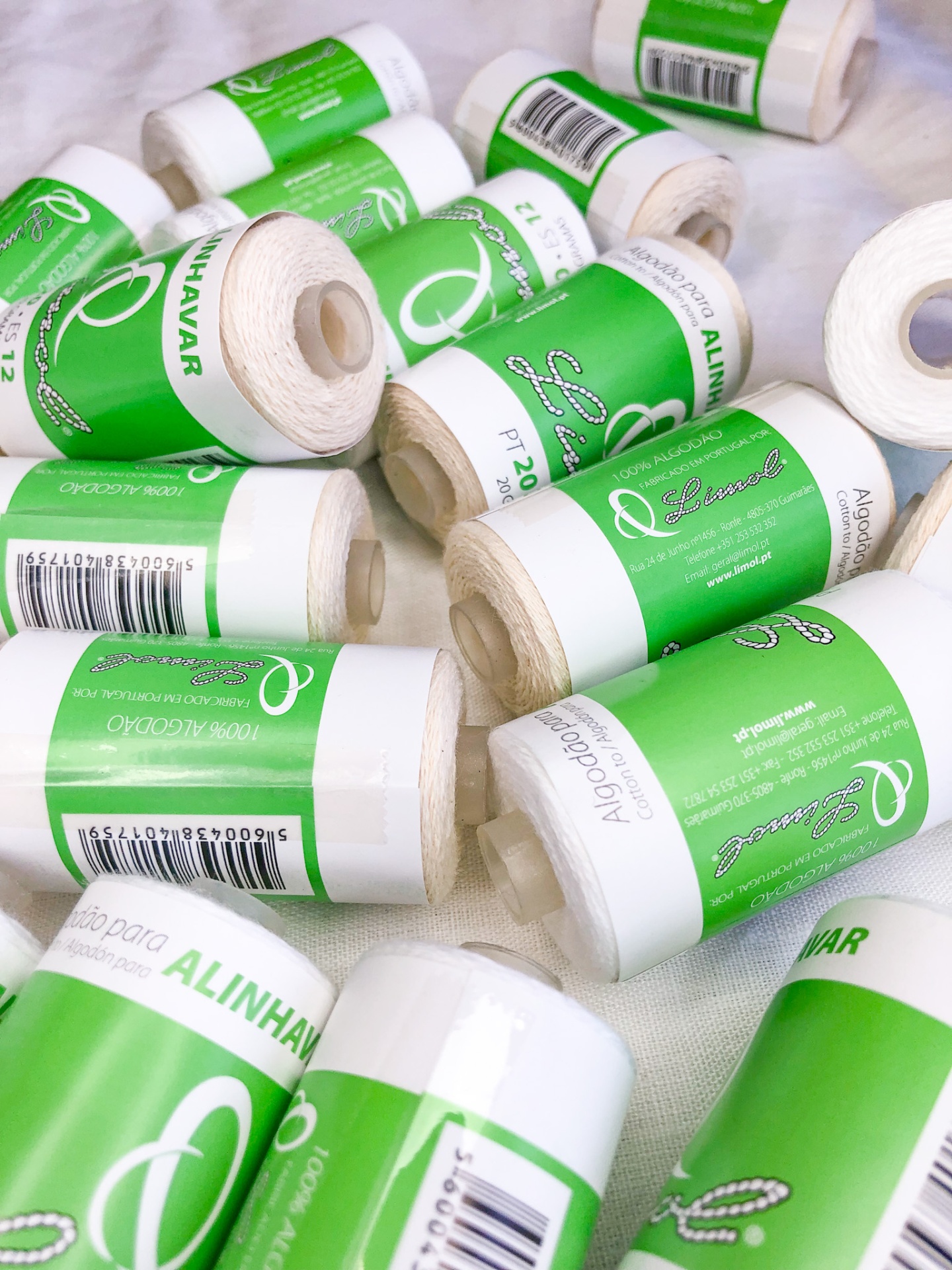 Rolos de linha de algodão com etiquetas verdes e brancas