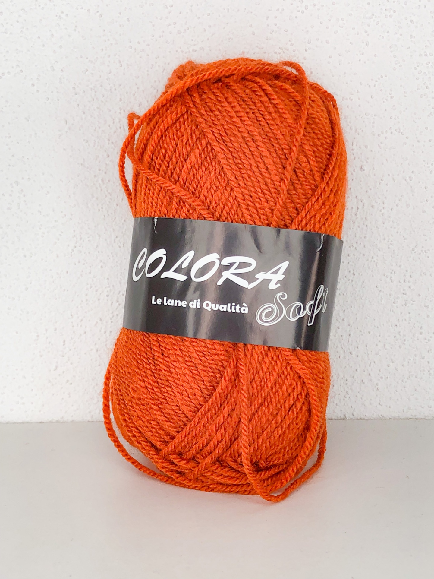 Novelo de lã laranja com etiqueta preta colorida