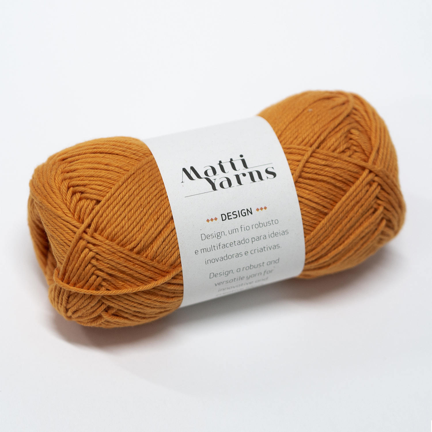 Novelo de lã castanha clara com etiqueta branca da Matti Yarns sobre fundo branco