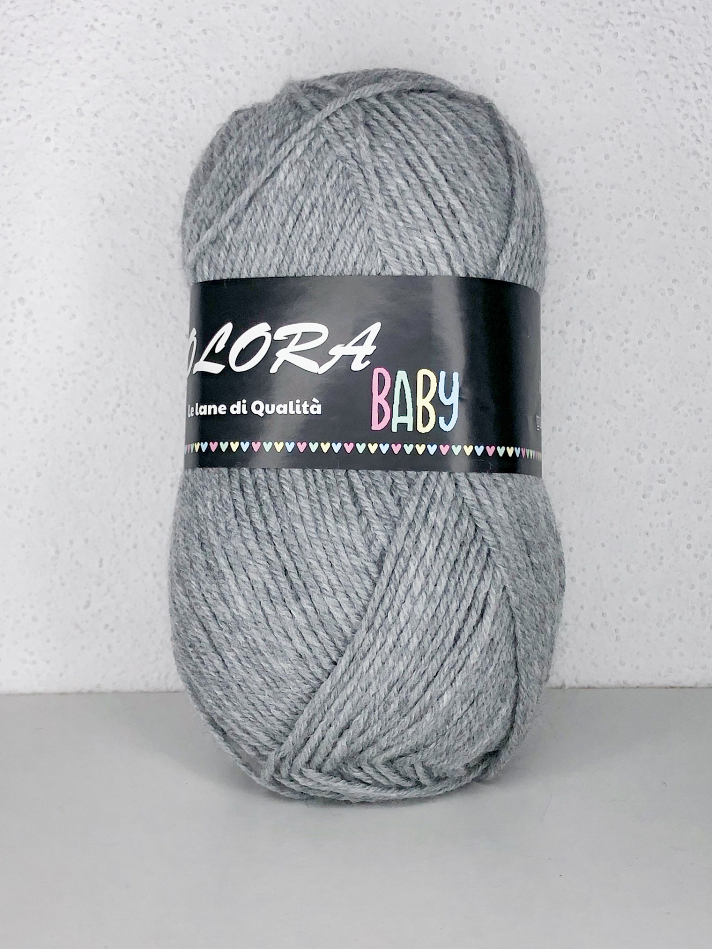 Novelo de lã cinzenta com etiqueta preta e texto colorido