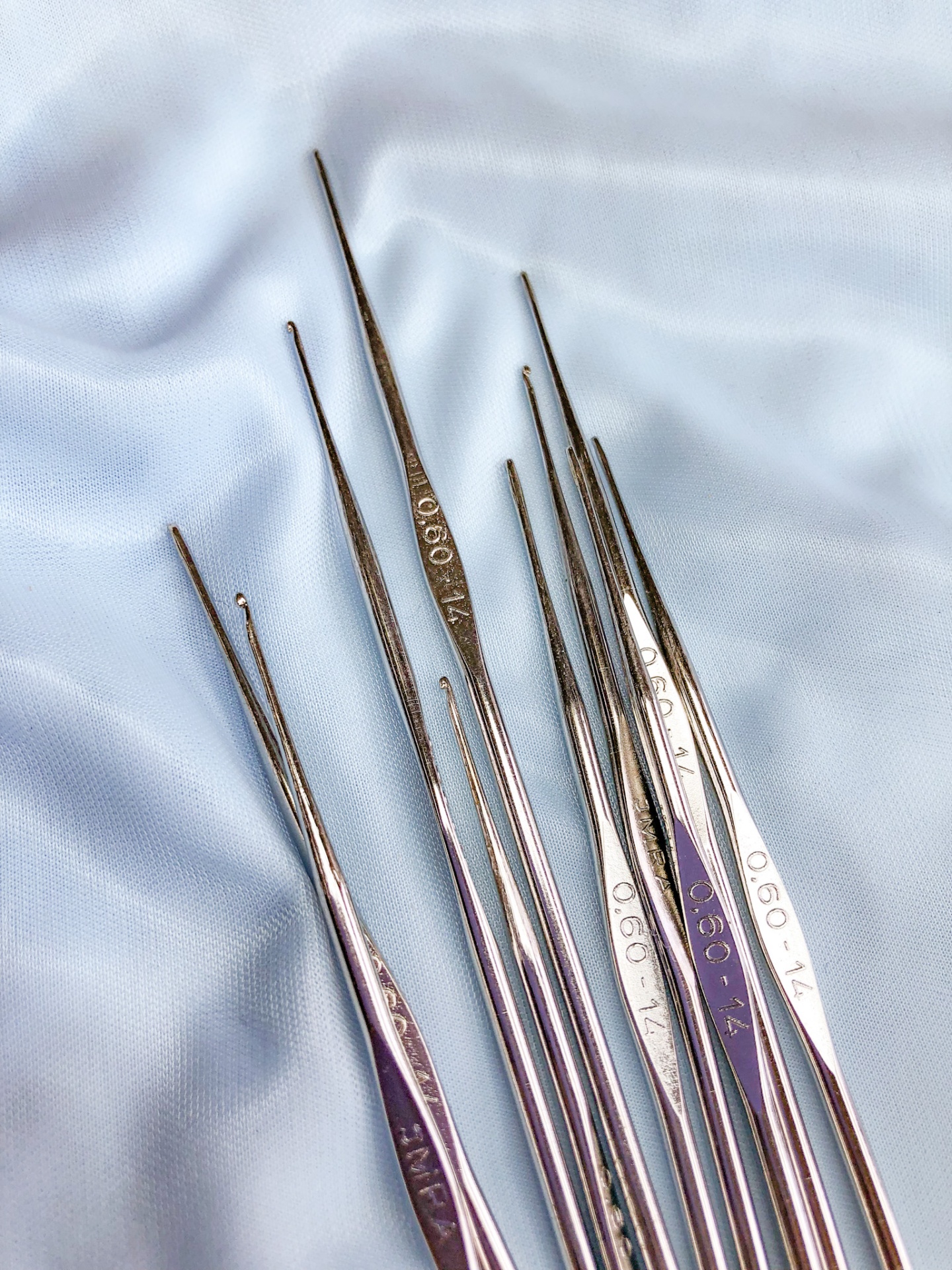 Agulhas metálicas finas para costura ou crochet sobre tecido azul claro