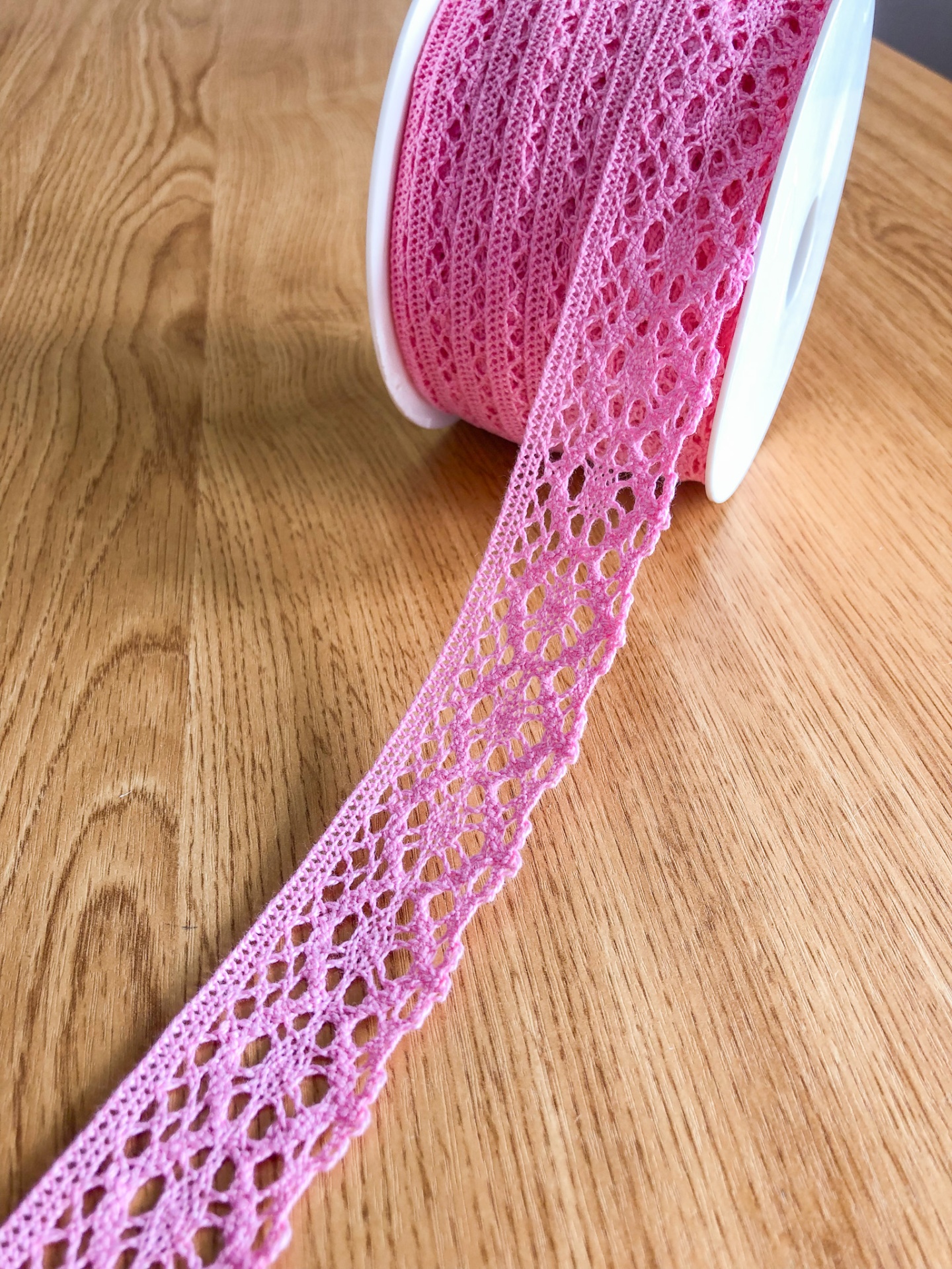 Rolo de renda rosa em madeira clara