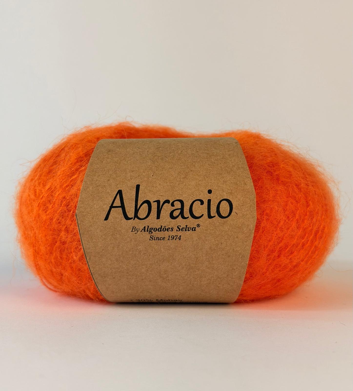 Novelo de lã laranja com rótulo Abracio