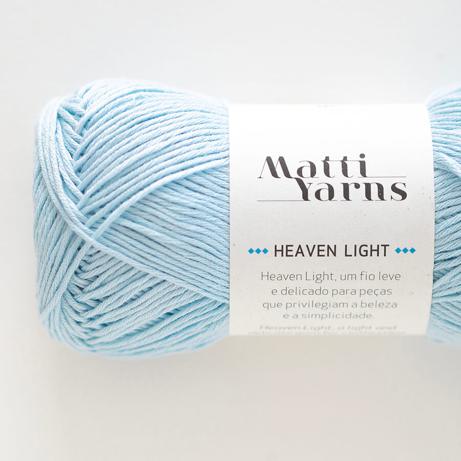 Novelo de fio azul claro da marca Matti Yarns com etiqueta branca