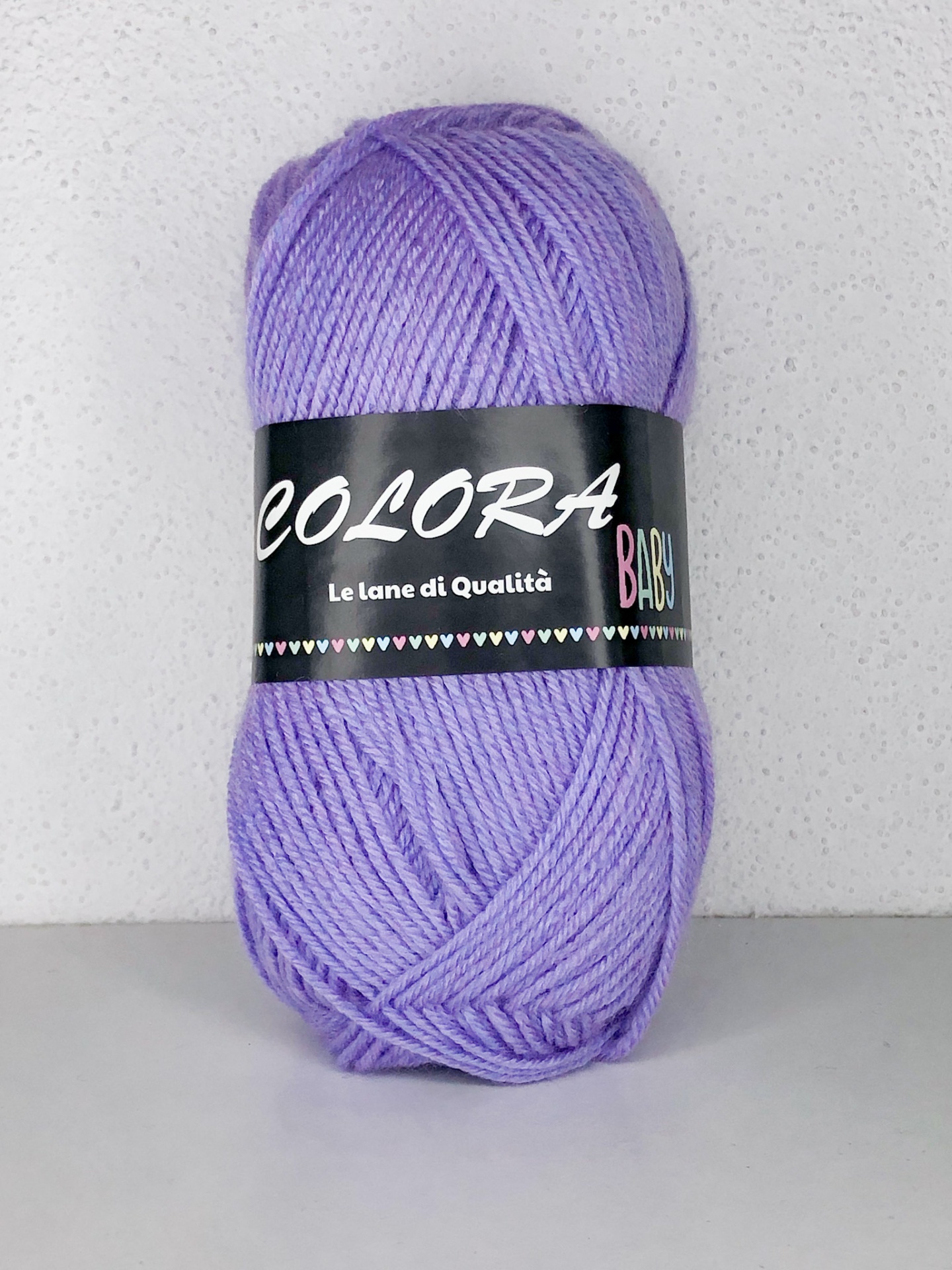 Novelo de lã lilás com etiqueta preta COLORA BABY