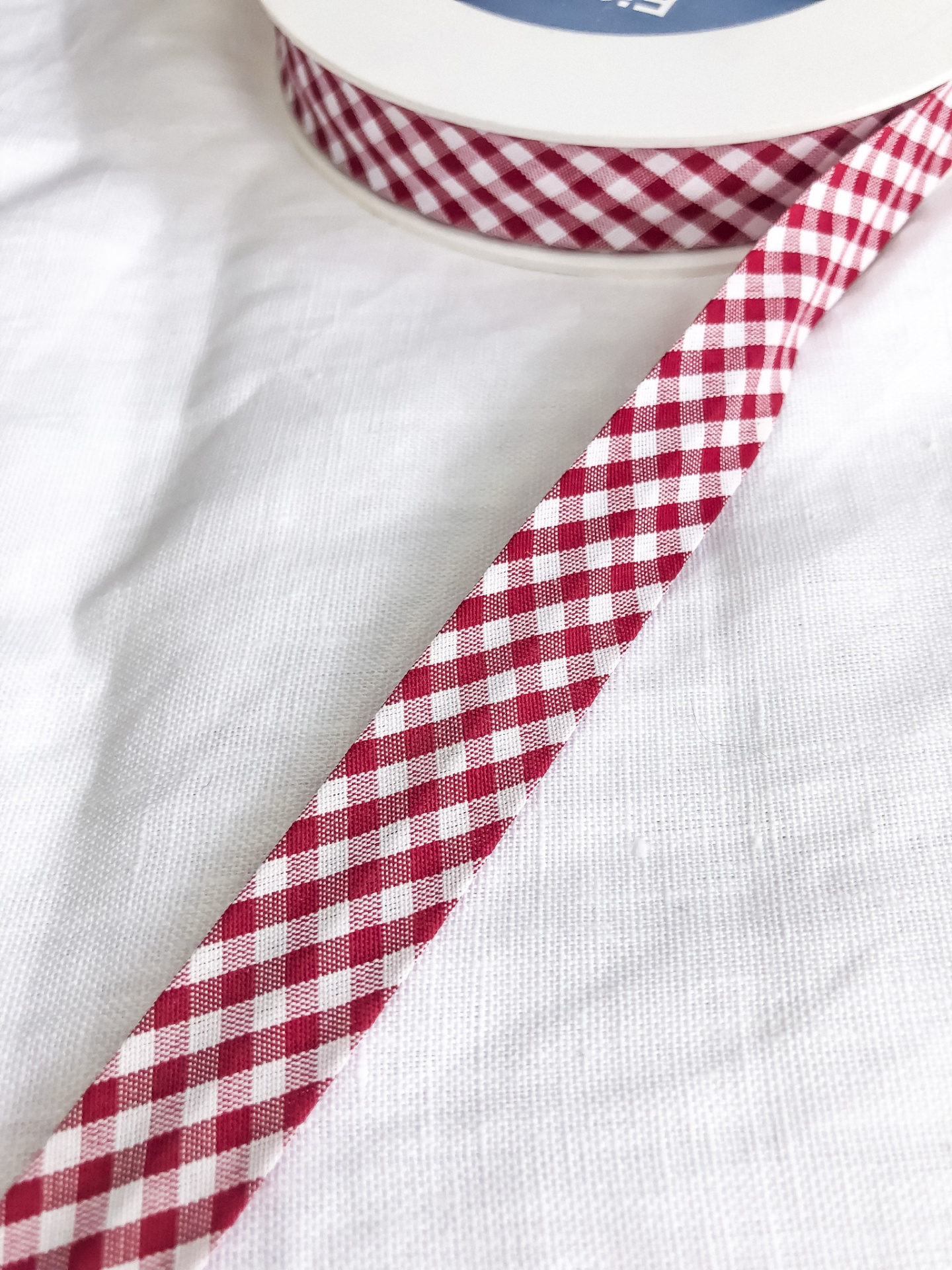 Fita de tecido vichy vermelha e branca enrolada