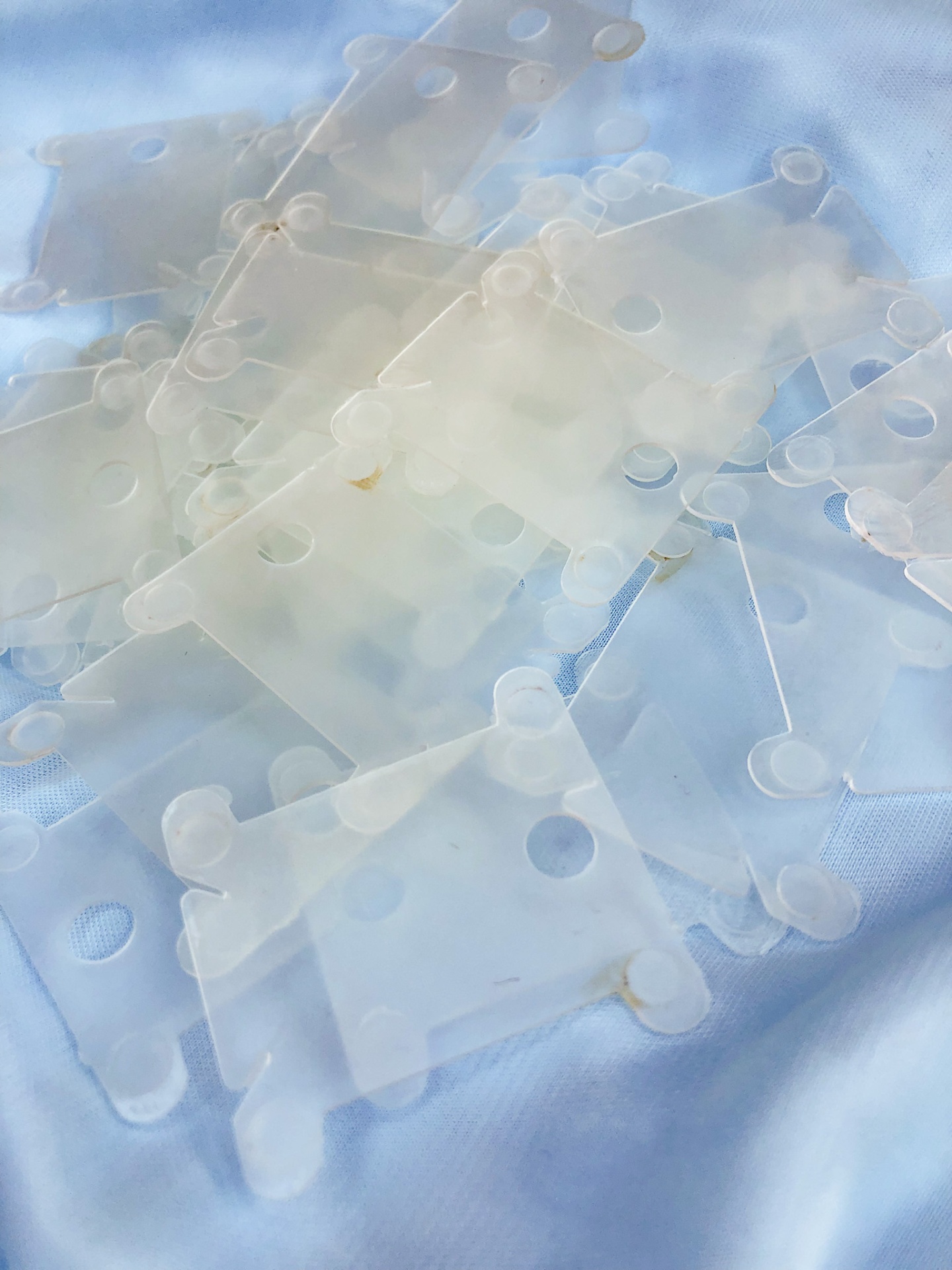 Organizadores de cabos transparentes em plástico sobre tecido azul claro