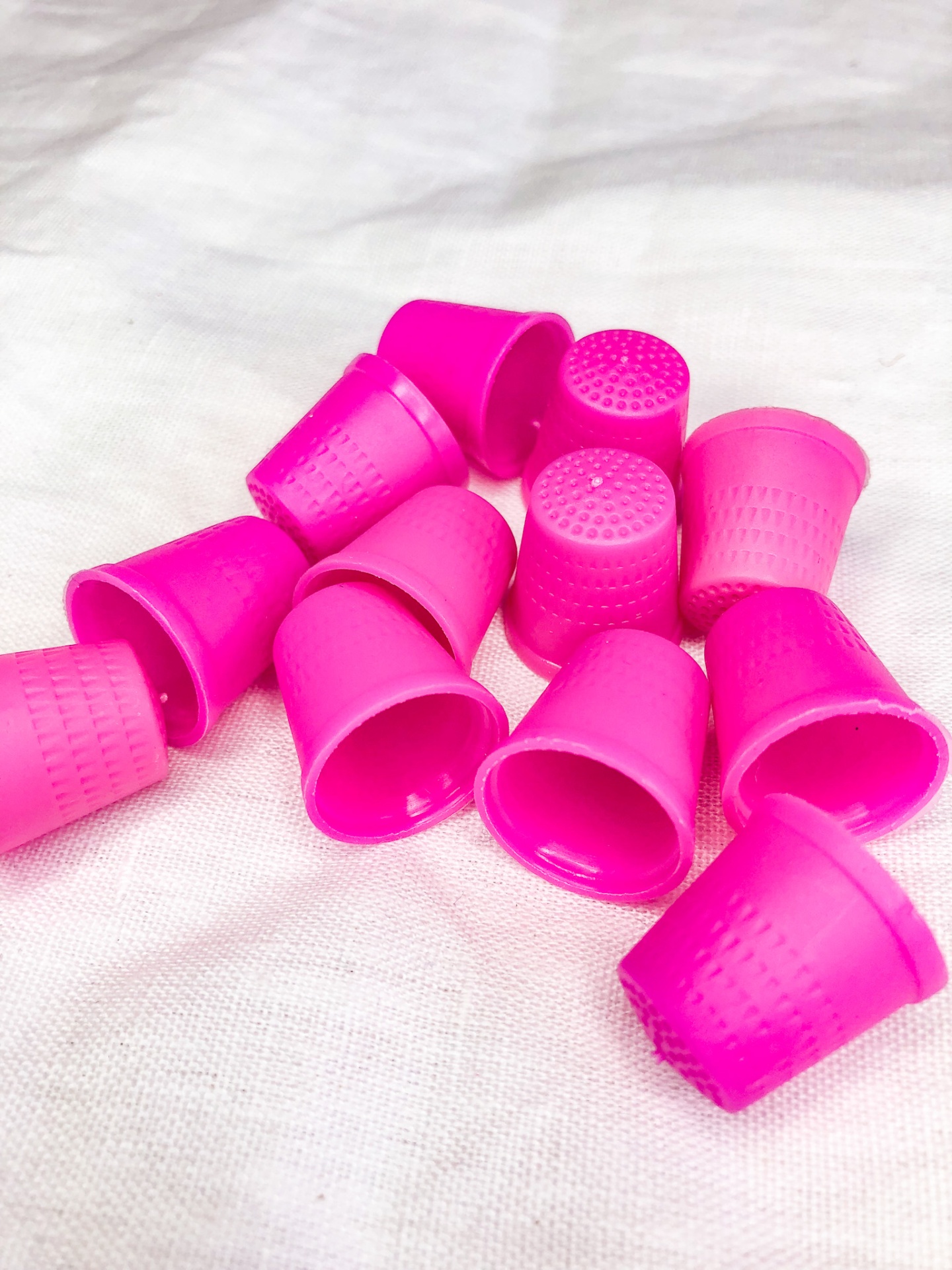 dedais cor-de-rosa em plástico com textura pontilhada sobre tecido branco