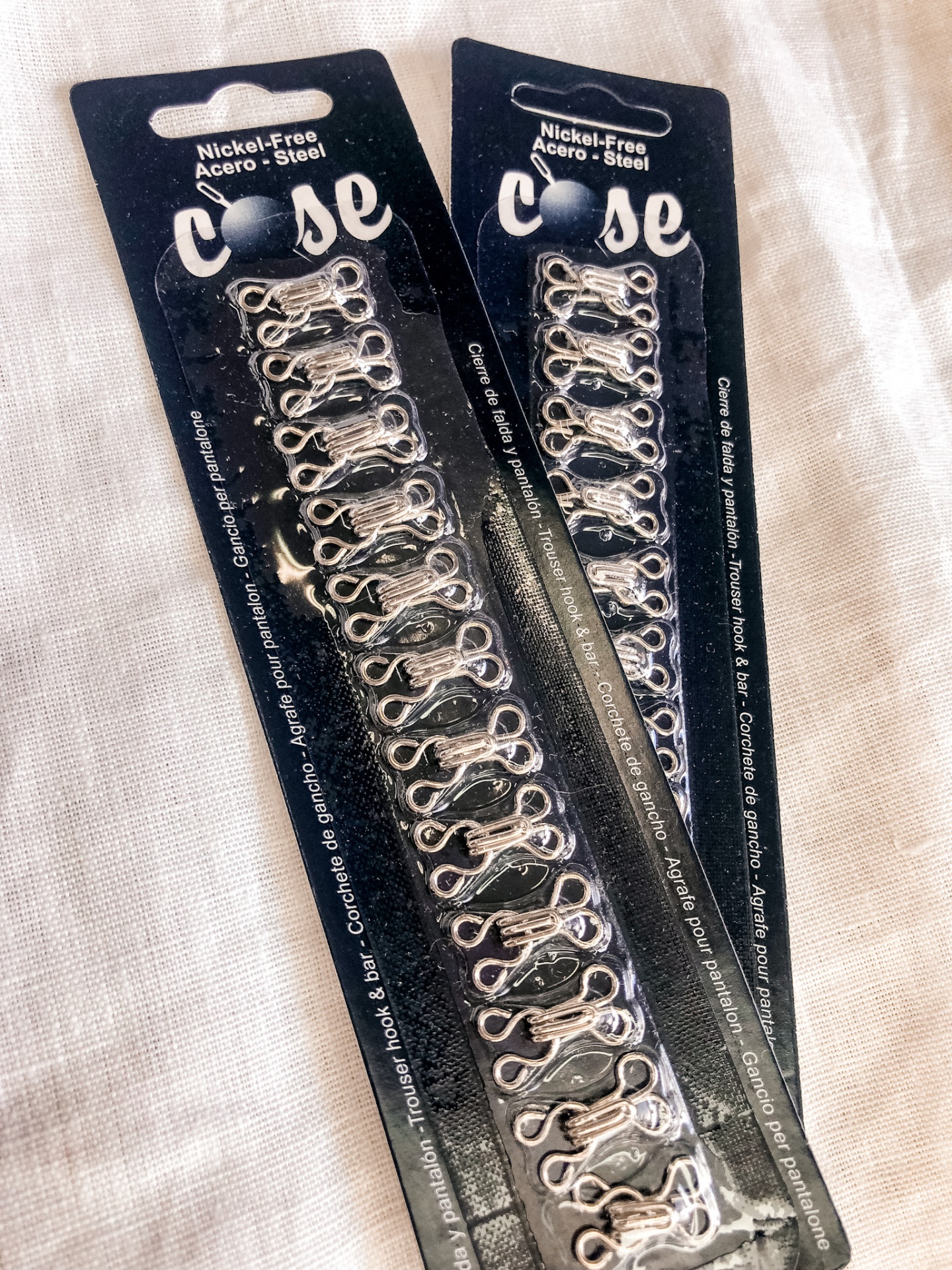 Pacotes de fechos metálicos para roupa em cartão preto com texto branco