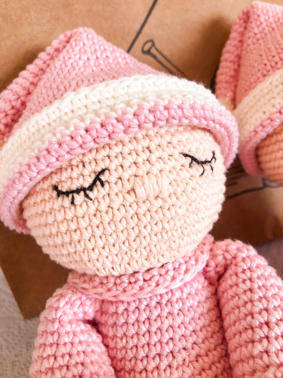 Boneco de croché rosa e bege com gorro