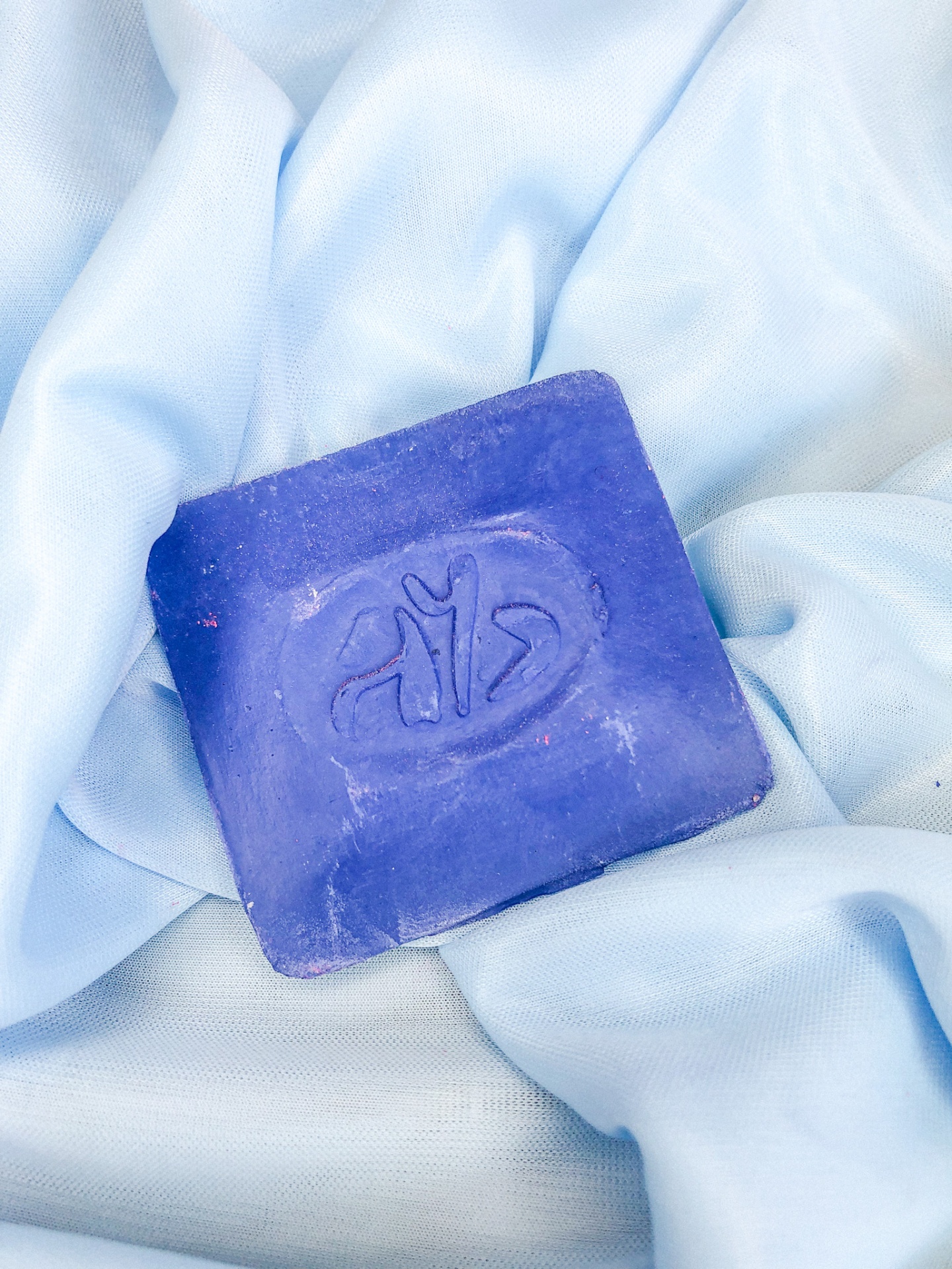 Sabonete azul quadrado sobre tecido azul claro