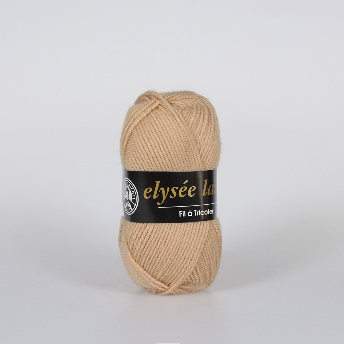 Novelo de fio bege claro para tricô com etiqueta preta e texto visível