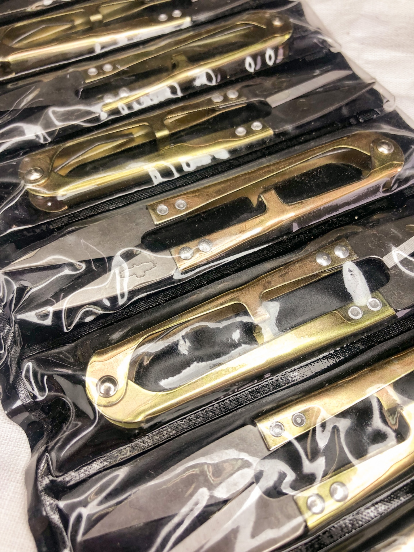 Conjunto de lâminas de barbear douradas organizadas em estojo preto com divisórias transparentes