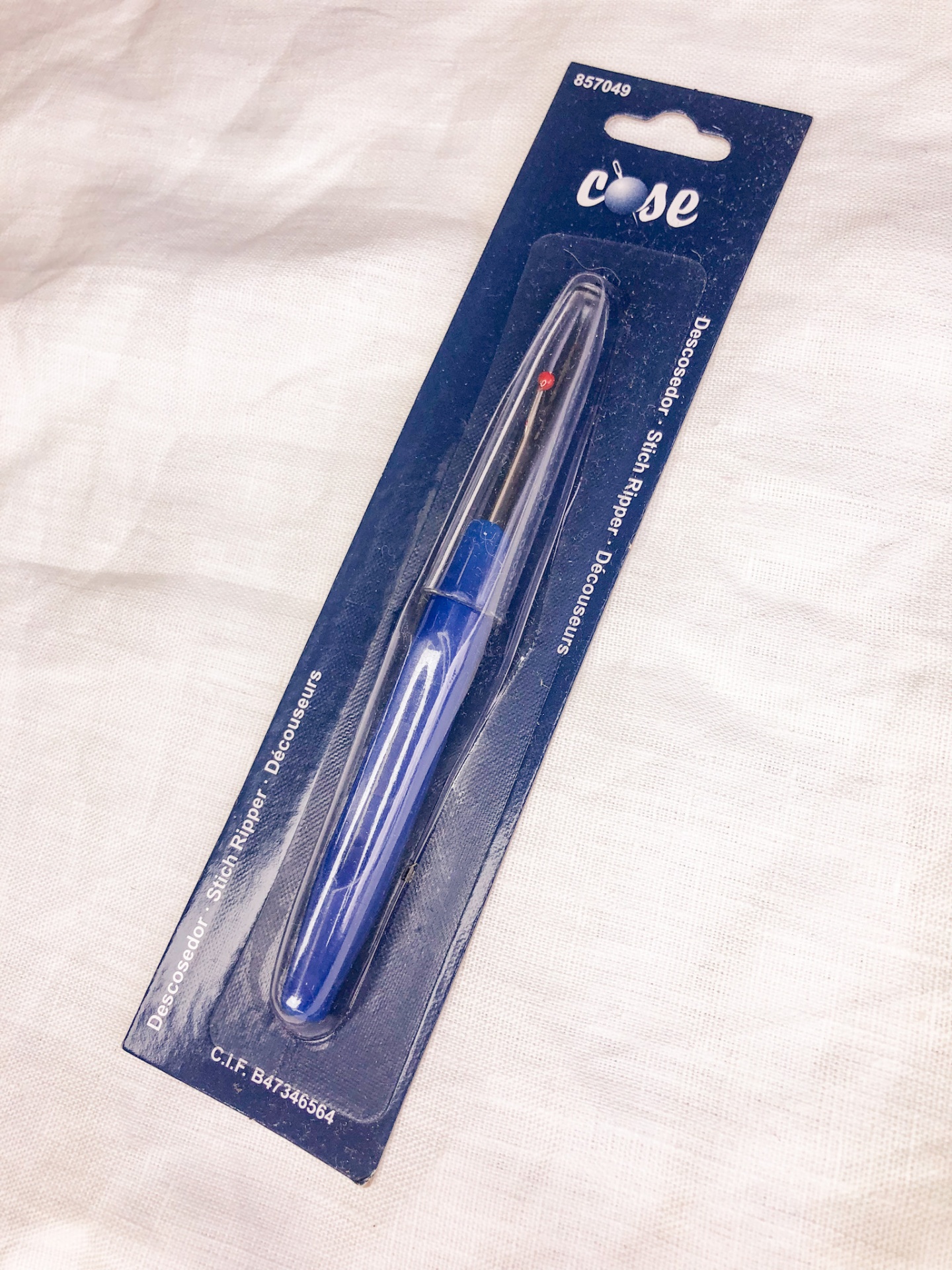 Removedor de etiquetas em embalagem azul sobre tecido claro