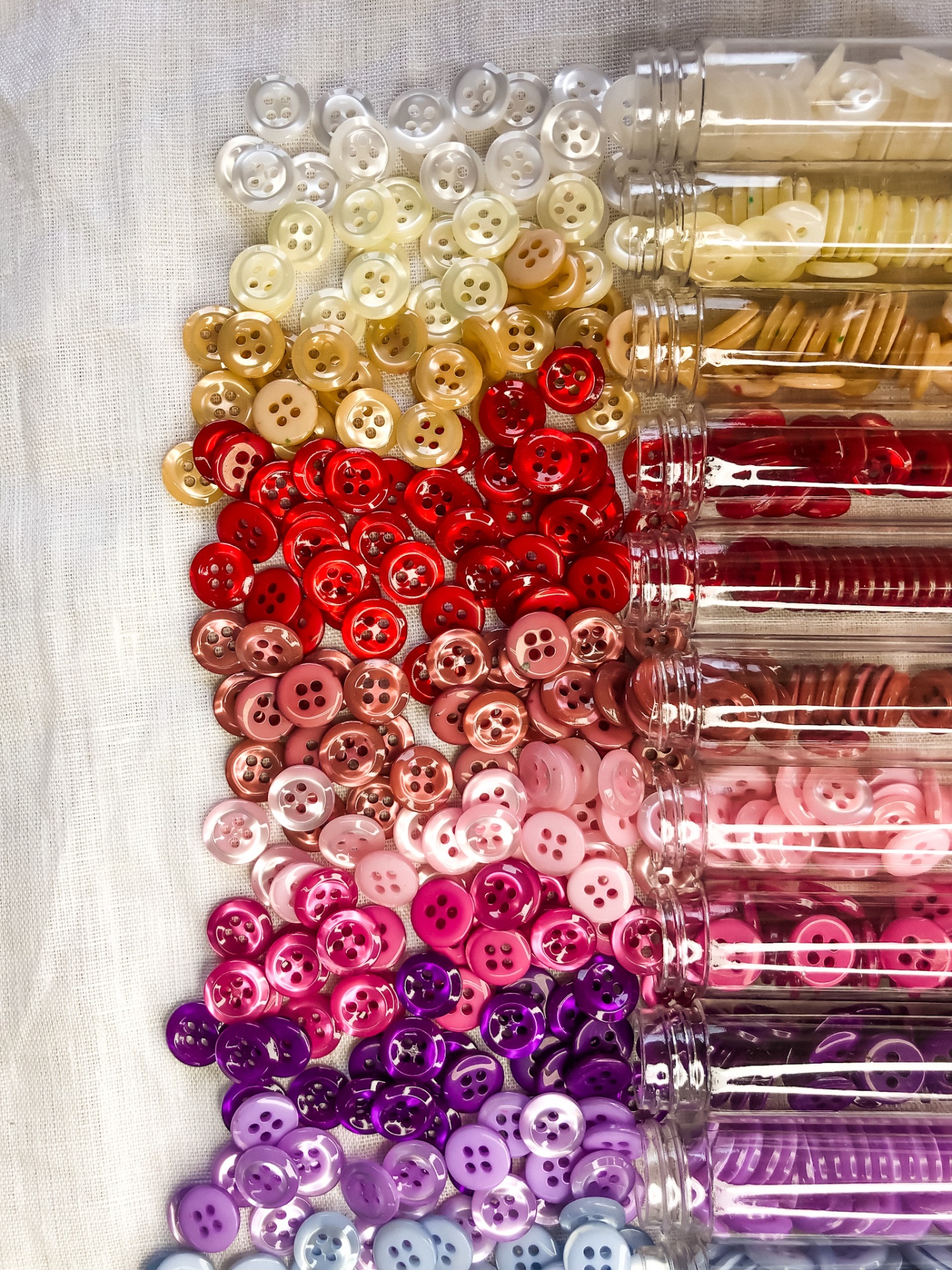 Diversos botões coloridos organizados ao lado de tubos transparentes.