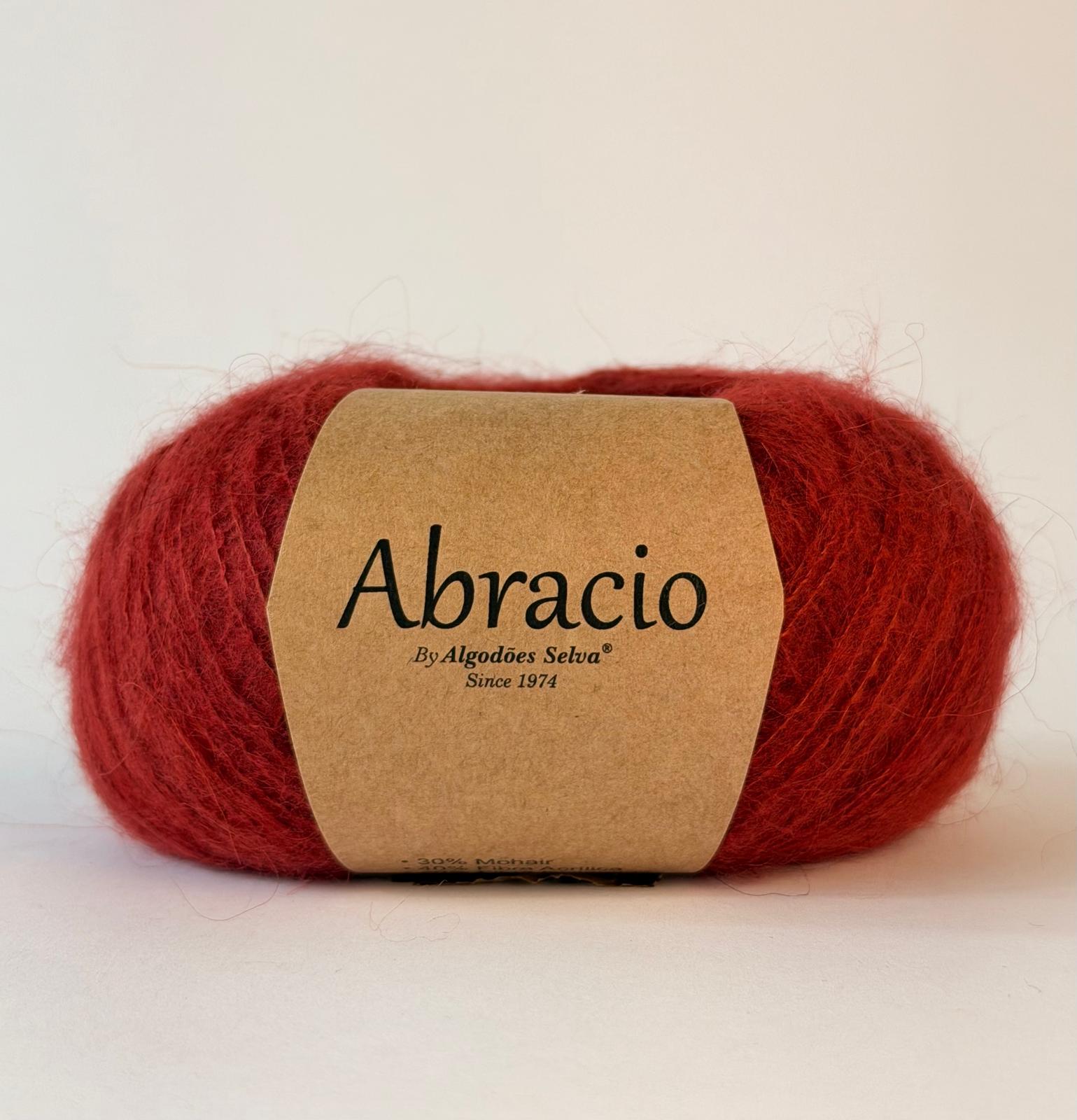 Novelo de lã vermelha com etiqueta Abracio