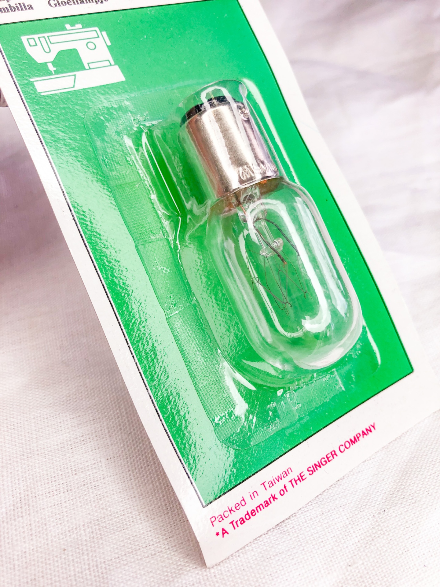 Lâmpada para máquina de costura embalada em cartão verde e plástico transparente