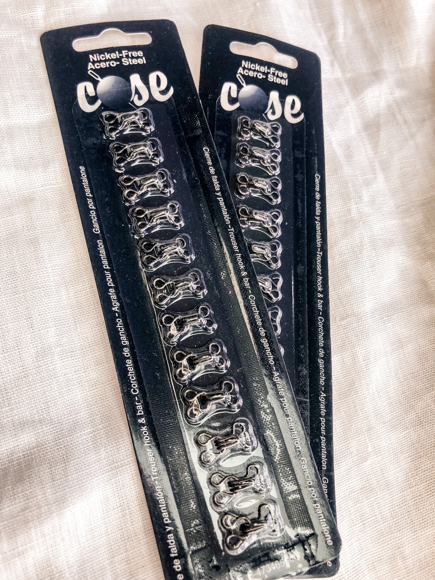 Pacotes de peças metálicas prateadas em embalagem preta com texto