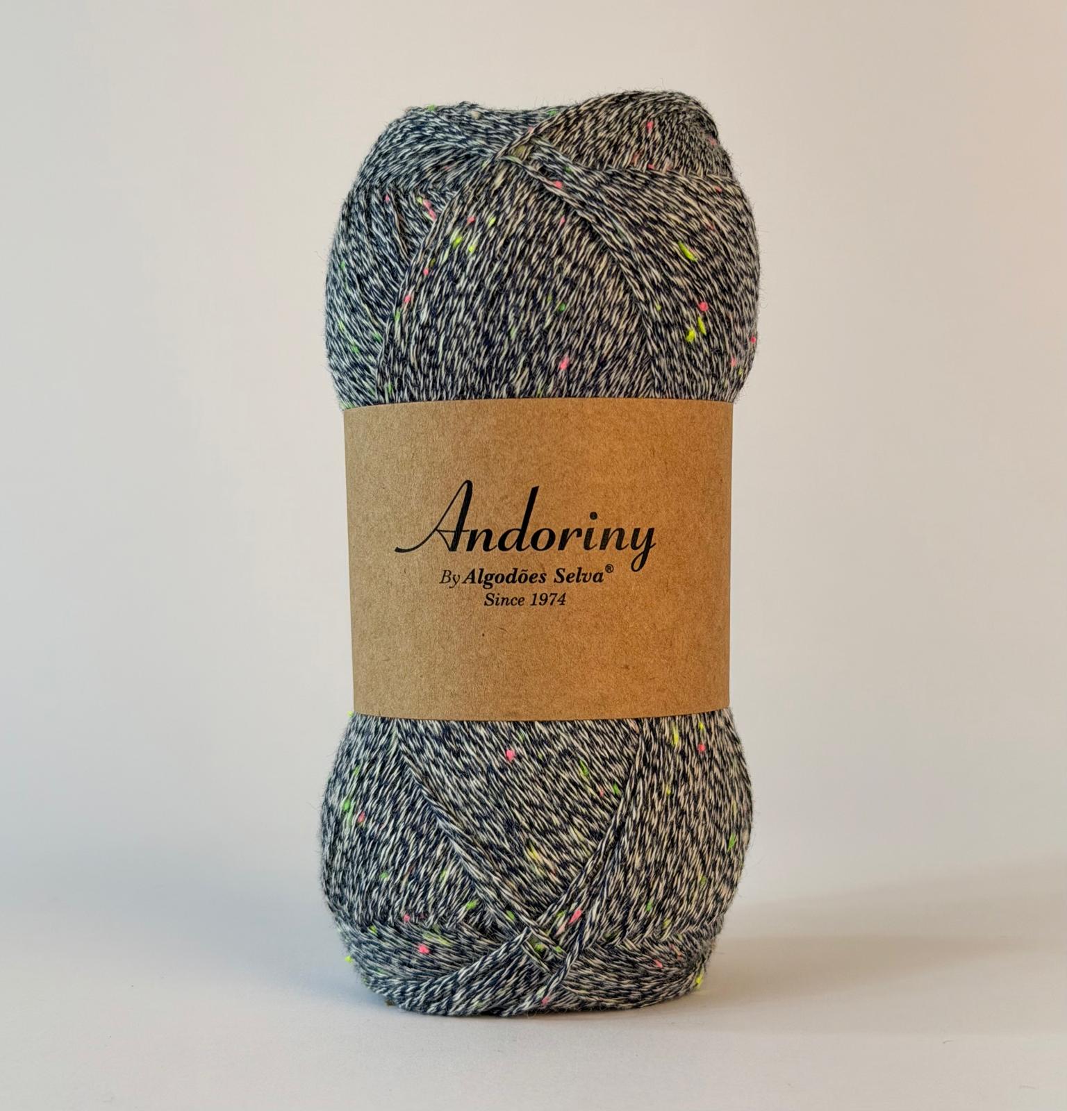 Novelo de fio cinzento com manchas coloridas e embalagem com texto