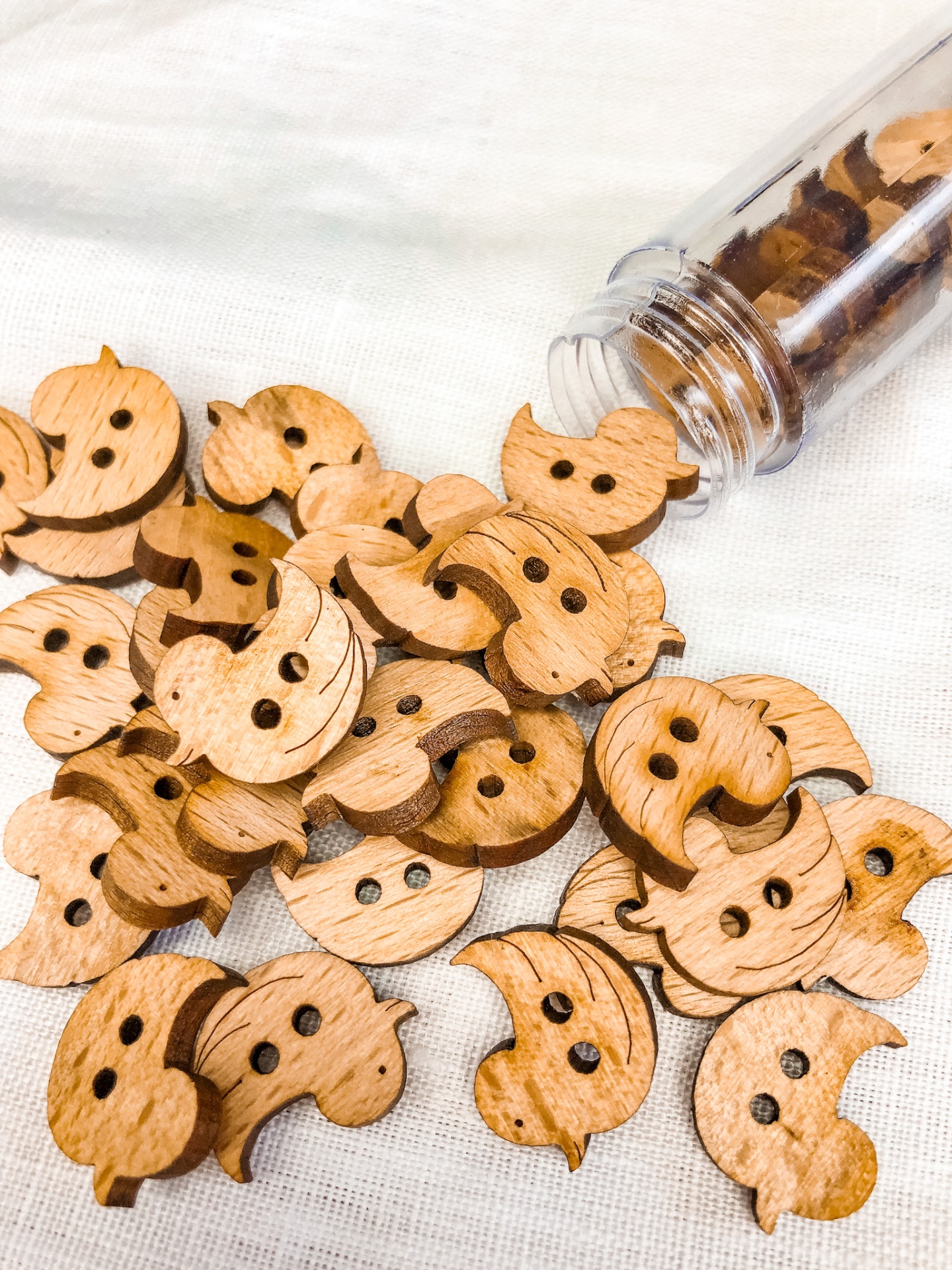 Botões de madeira em forma de coruja em tecido branco