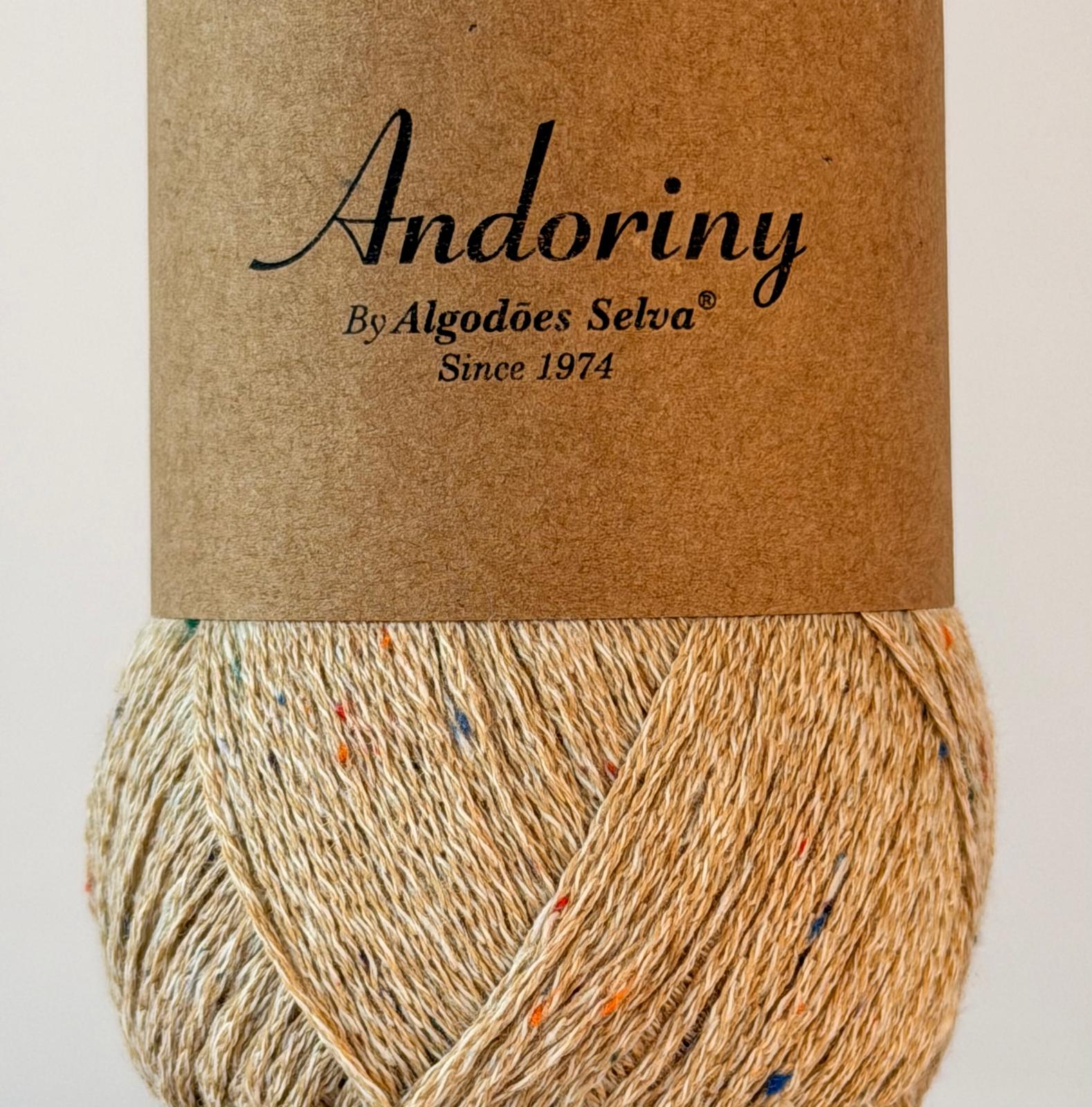 Novelo de fio bege com pontos coloridos e etiqueta de papel com texto