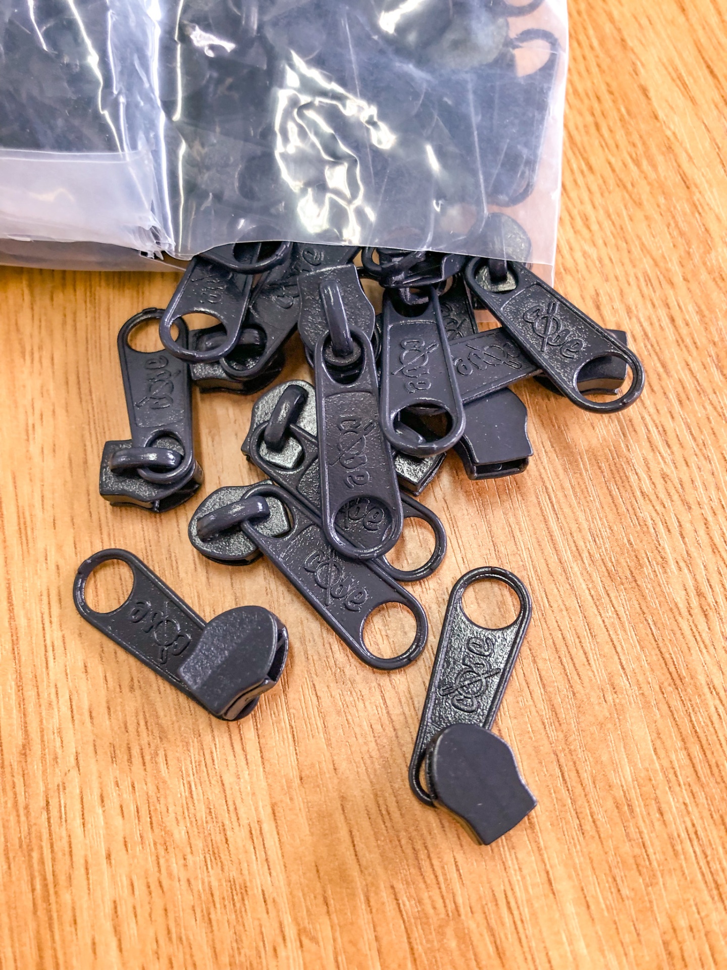 Fechos de zíper pretos em superfície de madeira clara