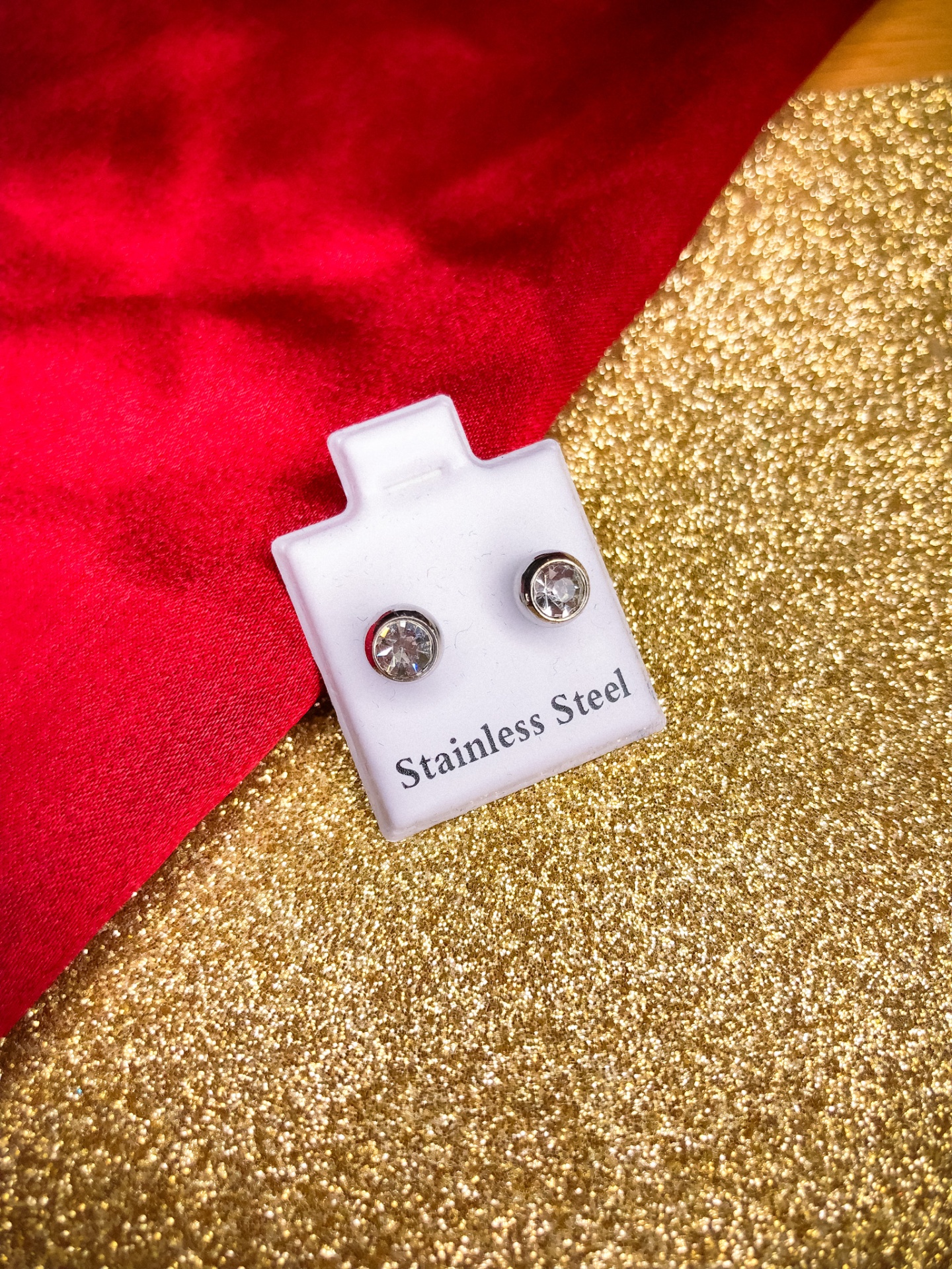 brincos em aço inoxidável com pedras brilhantes em suporte branco