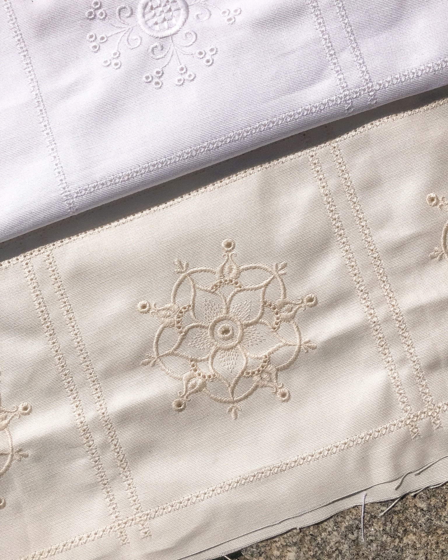 Tecidos branco e bege com bordado floral em relevo