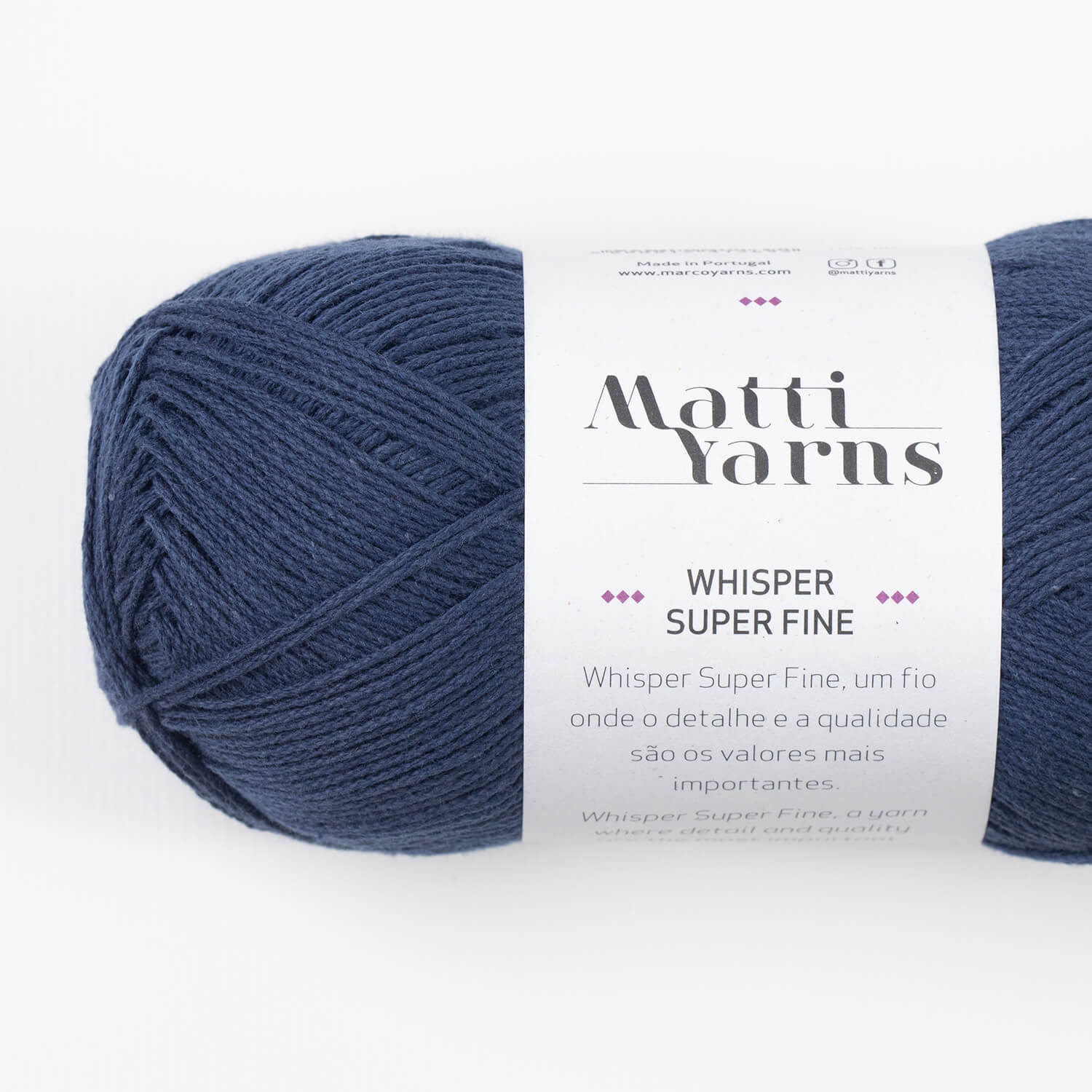 Novelo de fio azul escuro com etiqueta branca da marca Matti Yarns