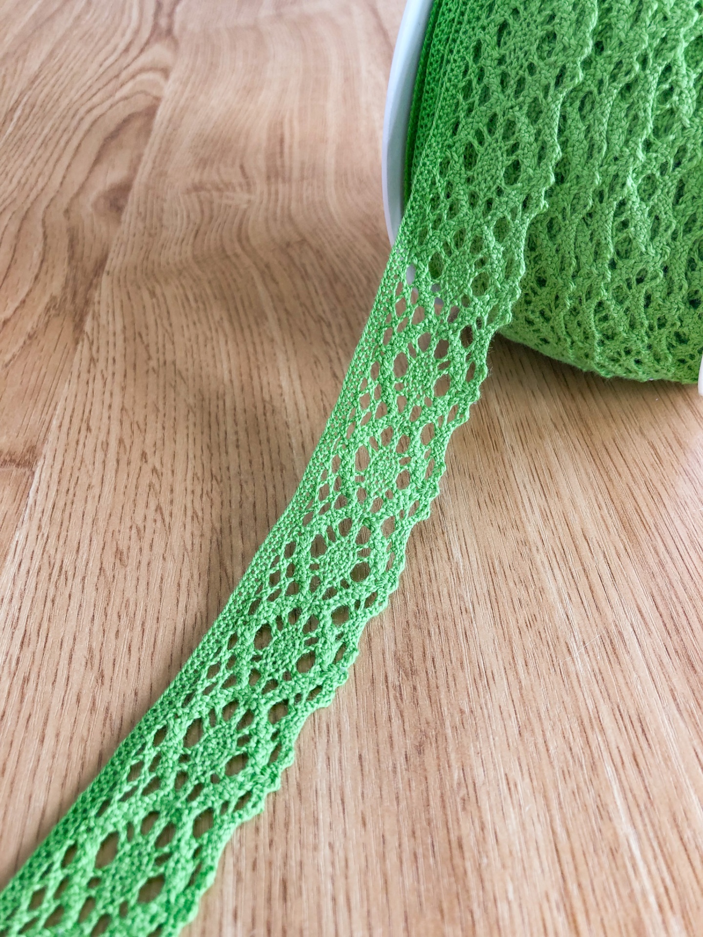 Rolo de renda verde sobre madeira clara