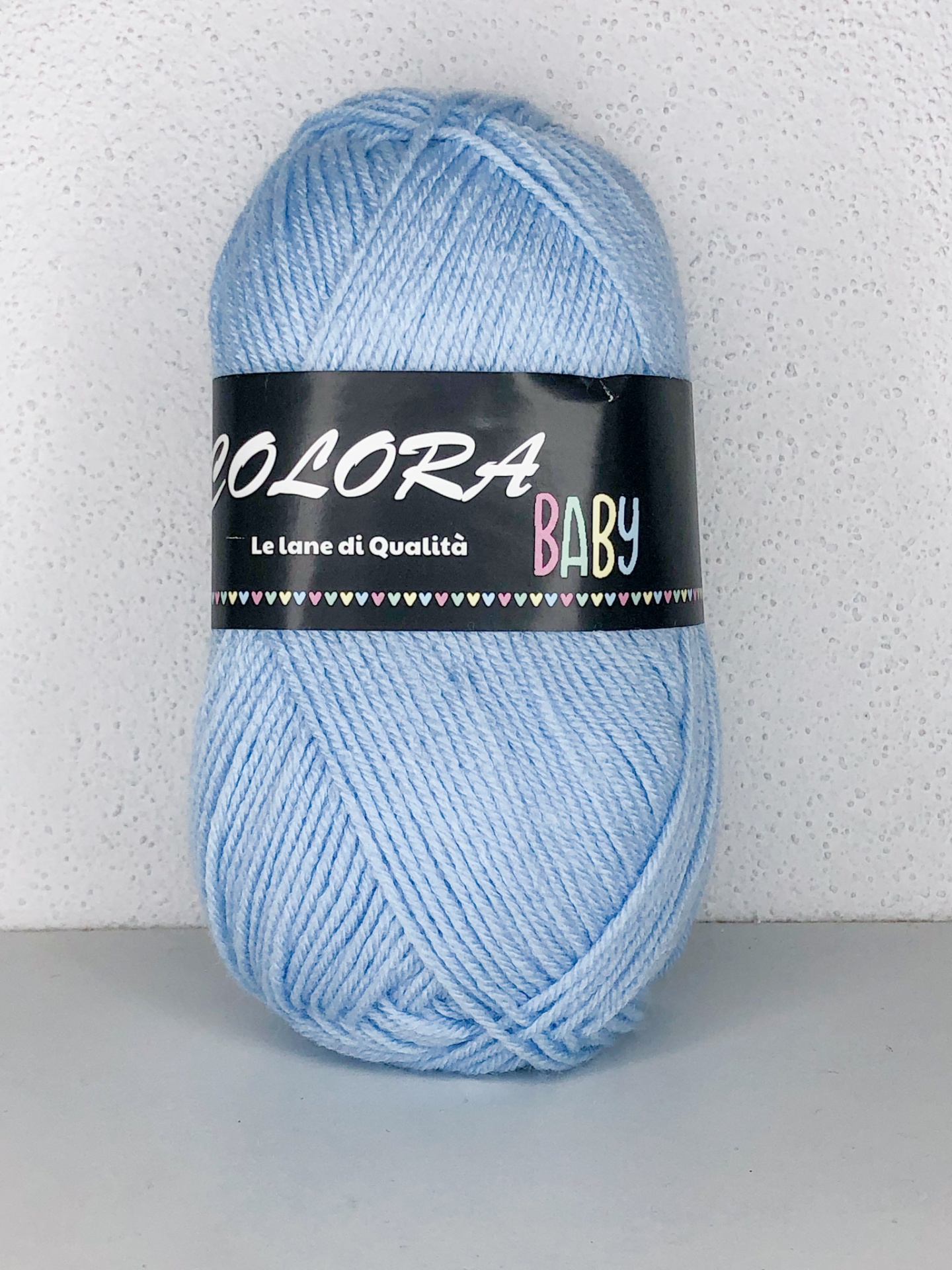 Novelo de lã azul claro com etiqueta preta COLORA BABY