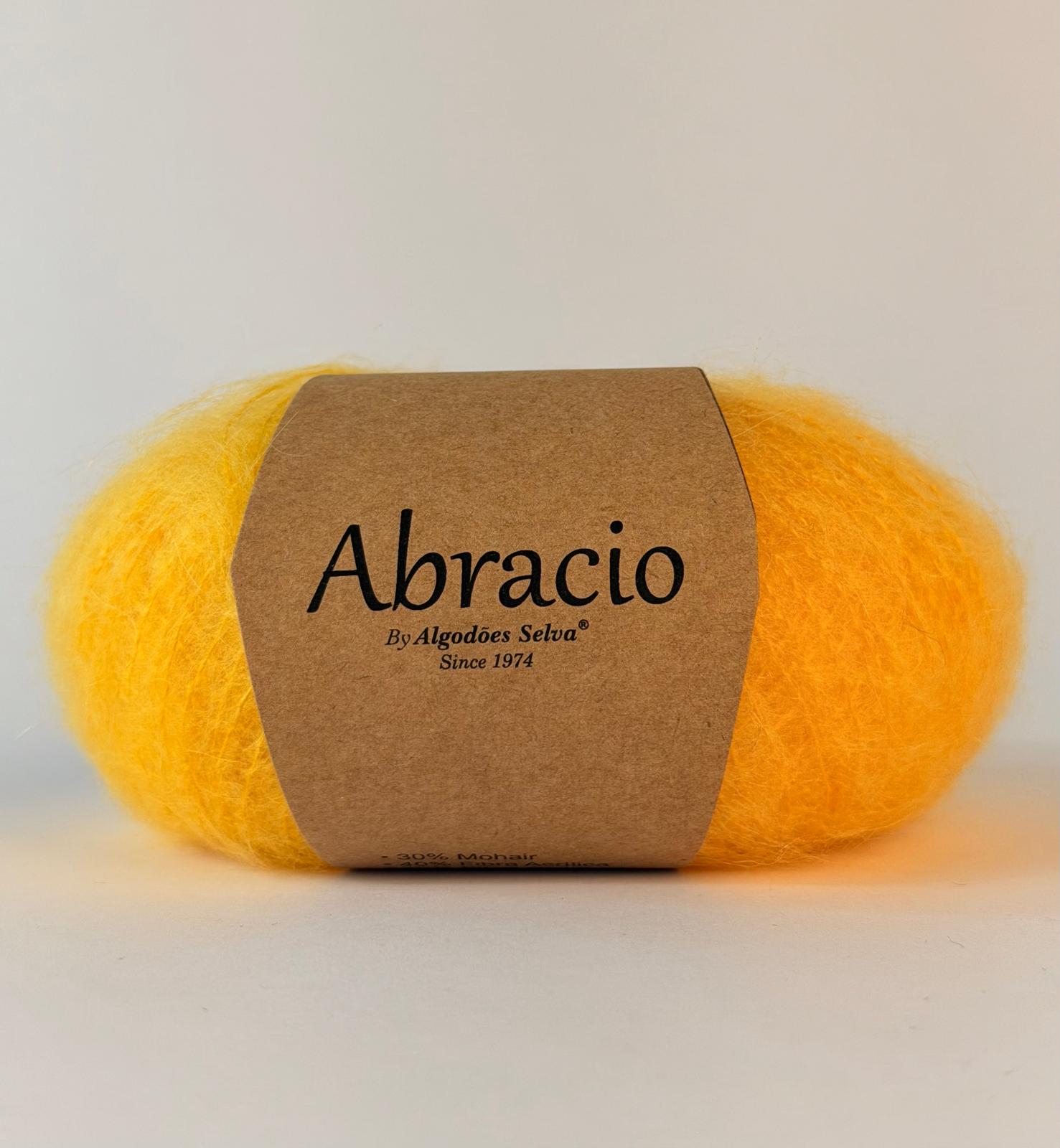 Novelo de fio amarelo com rótulo Abracio