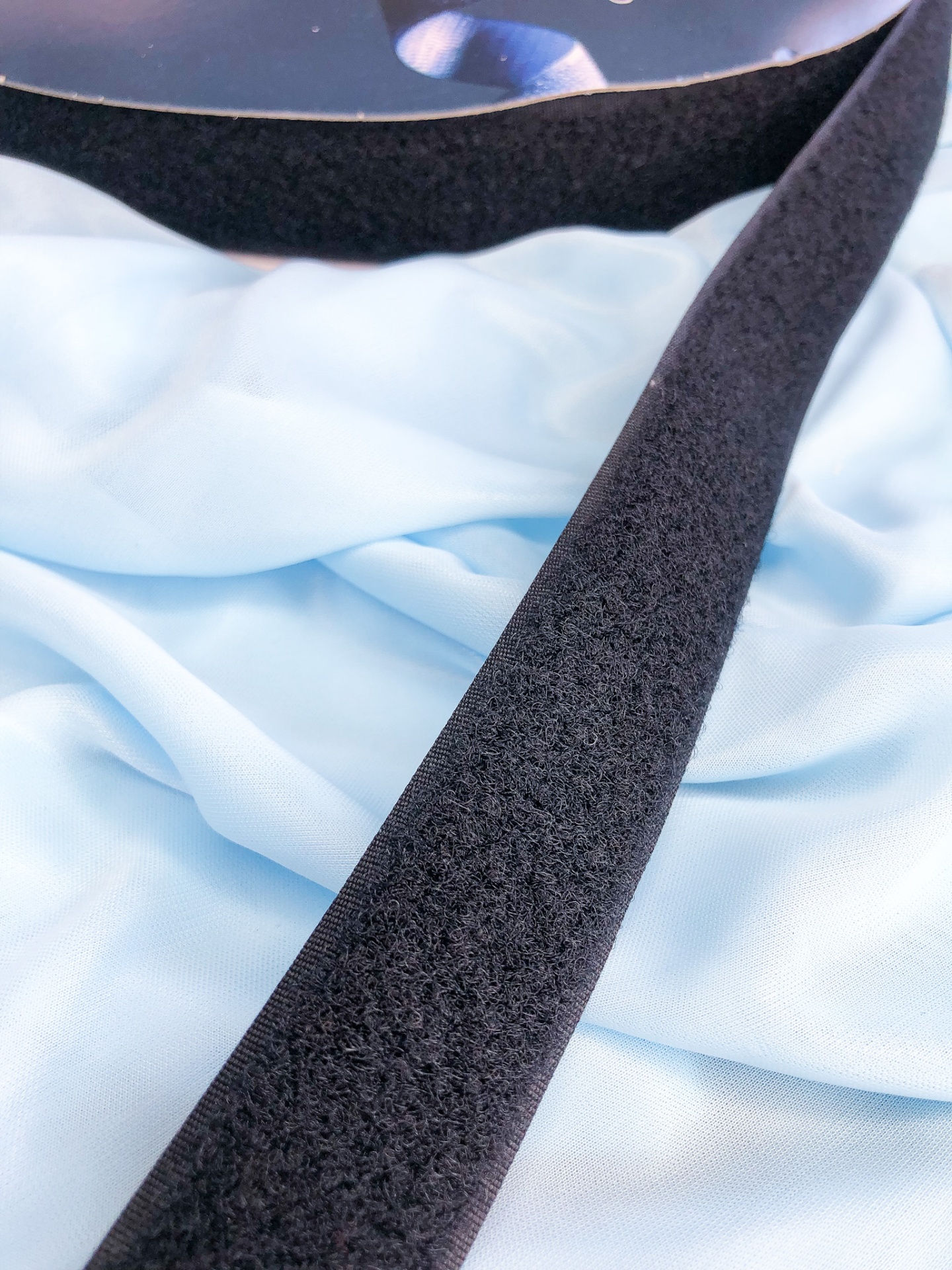 Tira preta felpuda sobre tecido azul claro