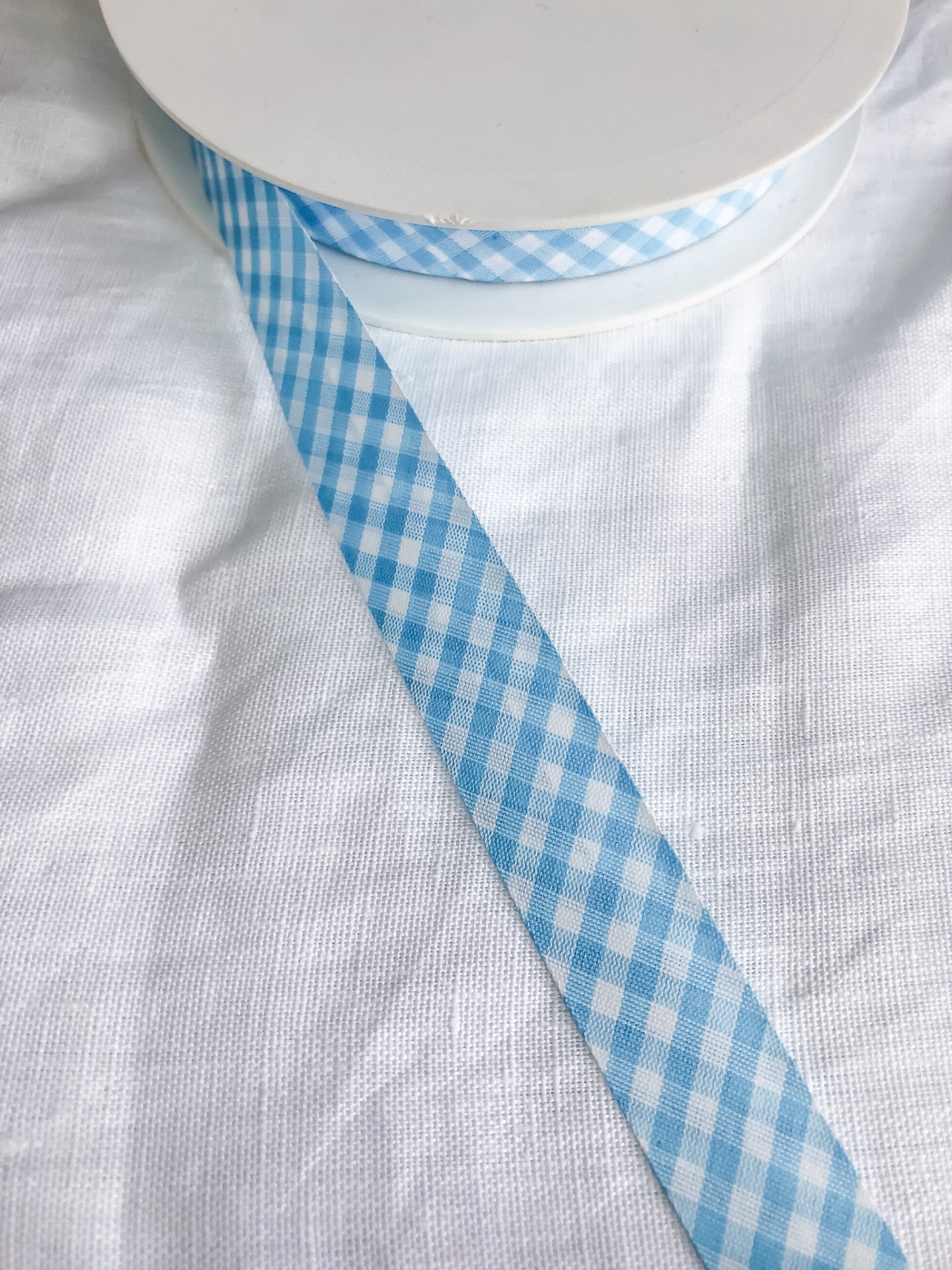 Fita azul e branca xadrez em rolo sobre tecido branco