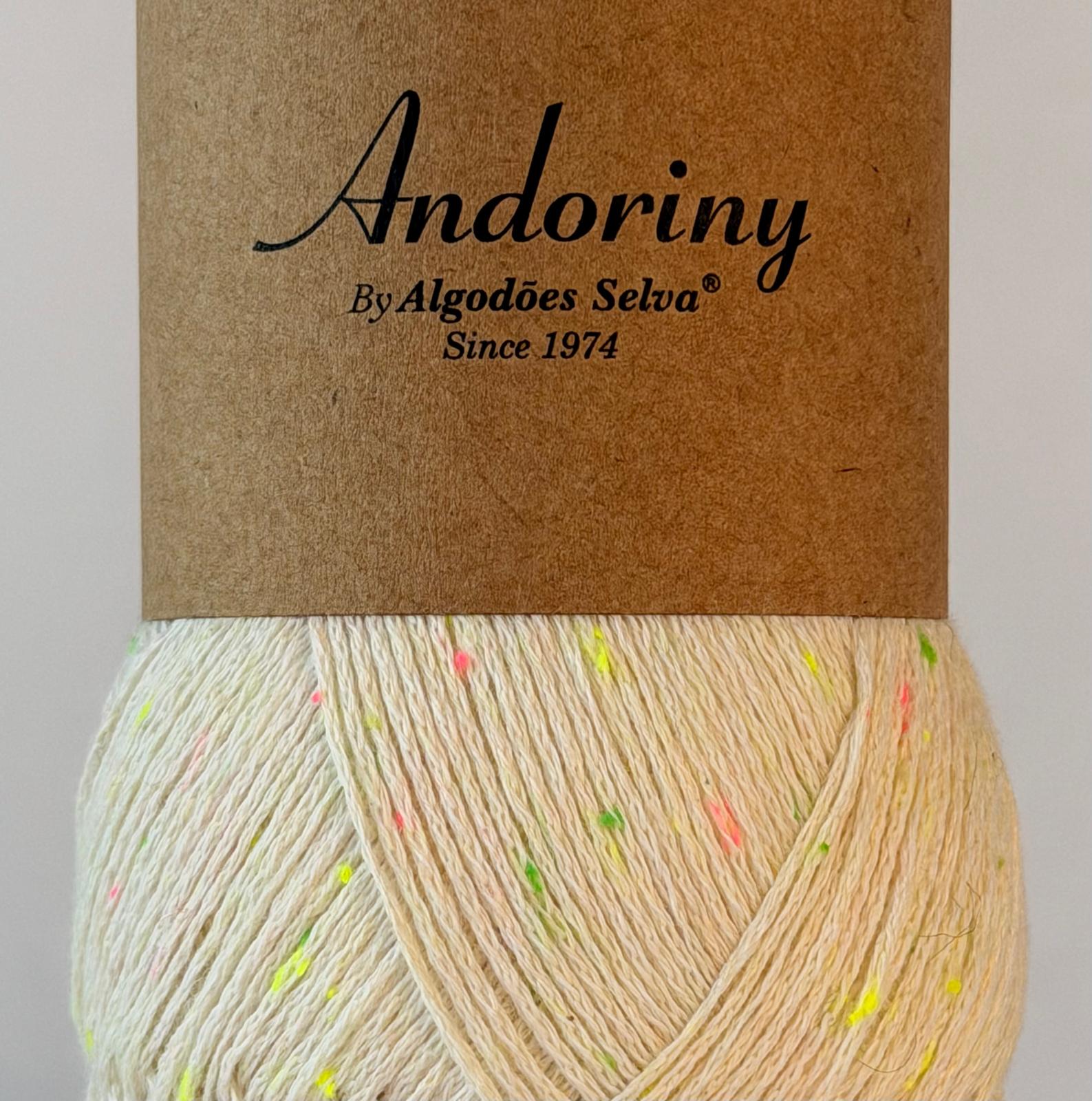 Novelo de fio de algodão cru com pontos coloridos e etiqueta castanha com texto