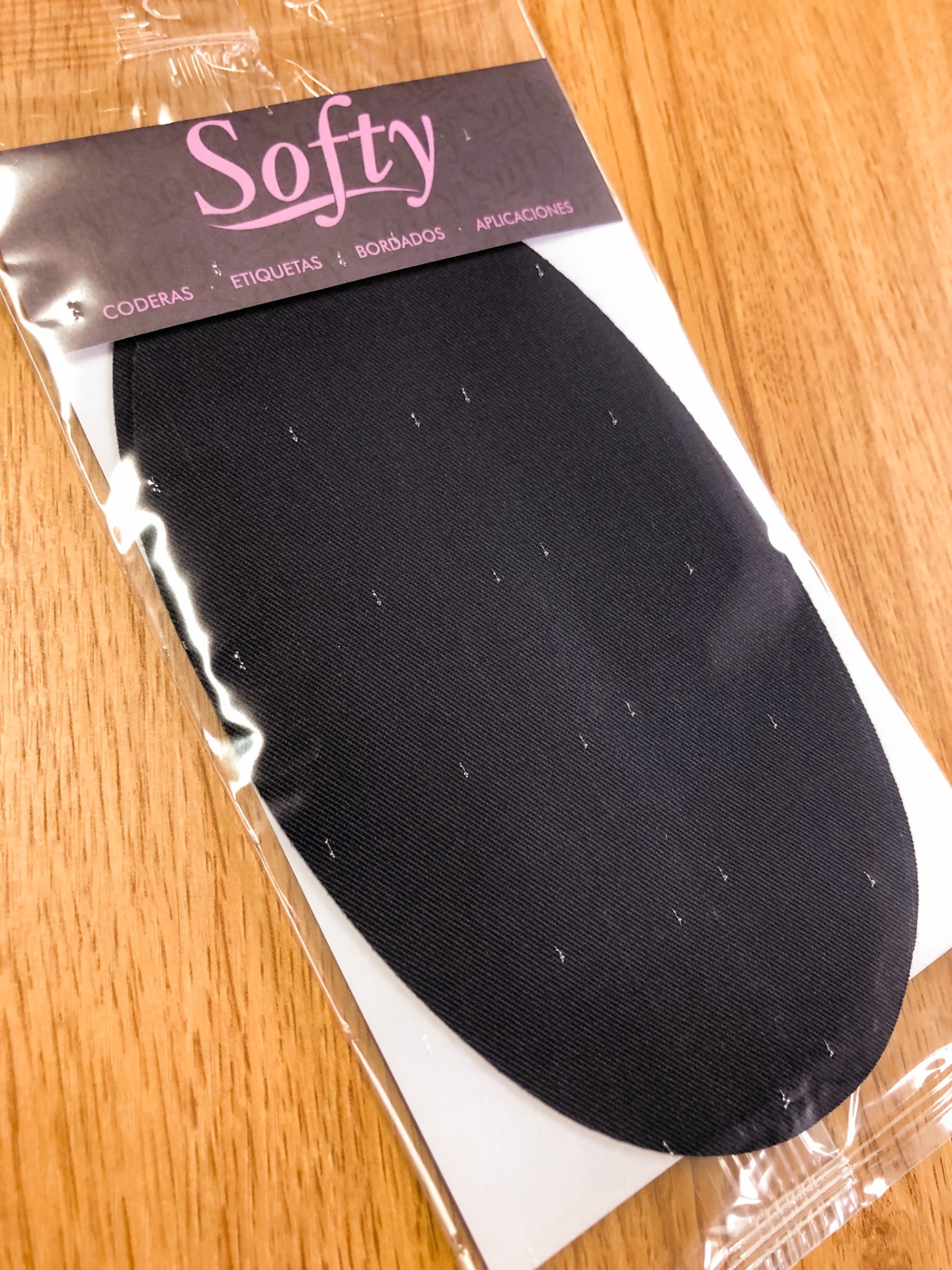 Pacote com codera preta Softy em superfície de madeira
