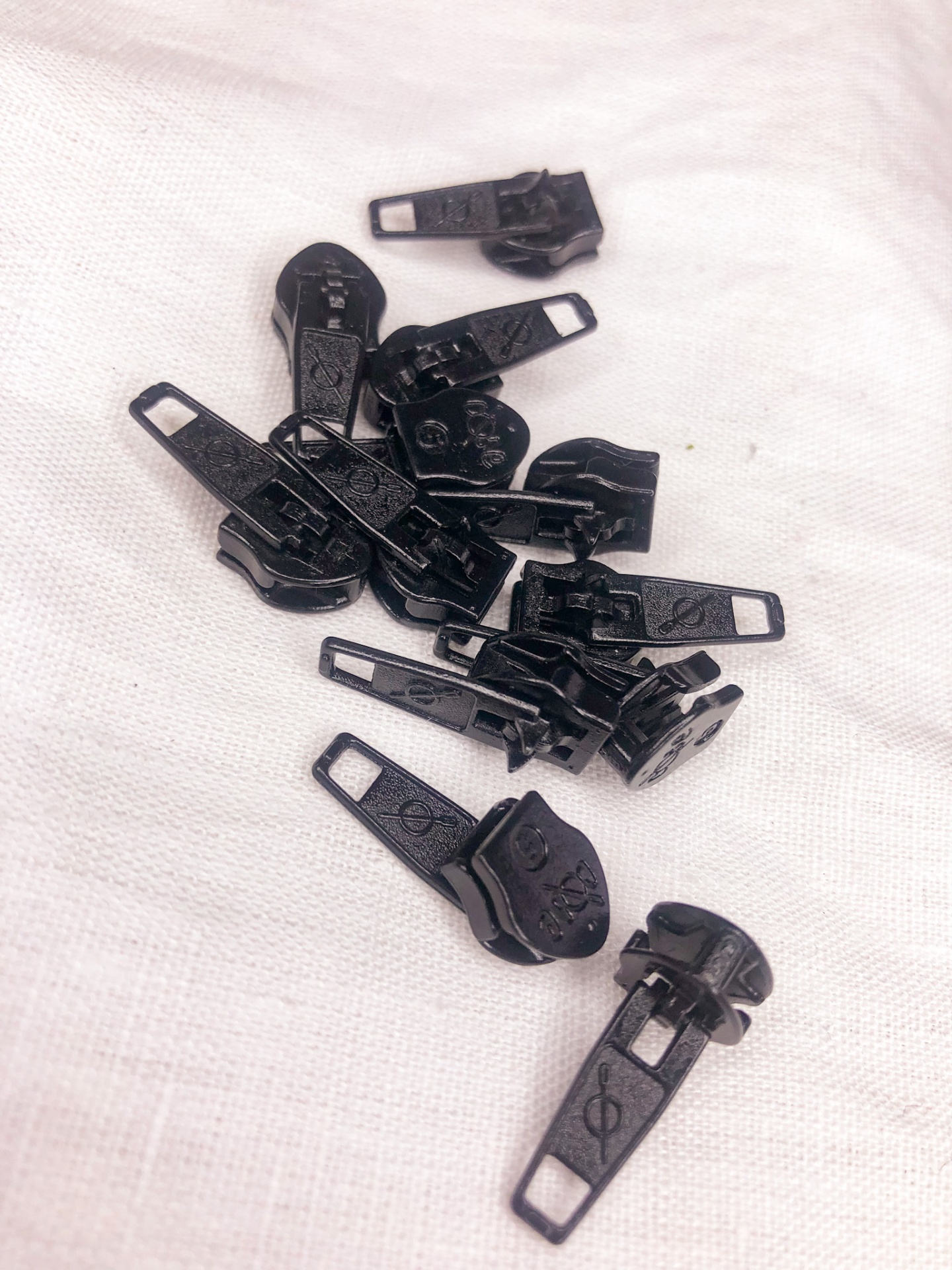 Cursores de zíper pretos em conjunto sobre tecido branco