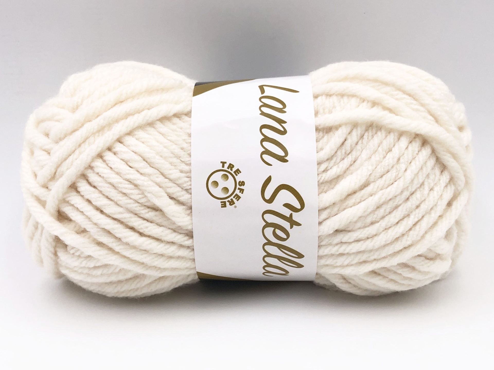 Novelo de fio de lã branco creme com etiqueta branca e texto dourado Lana Stella.