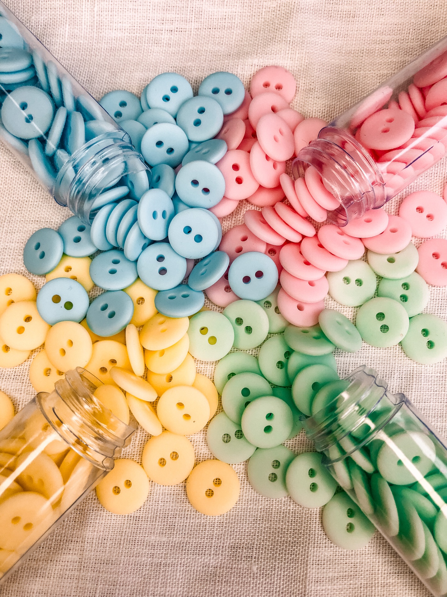 Botões coloridos em frascos sobre tecido claro