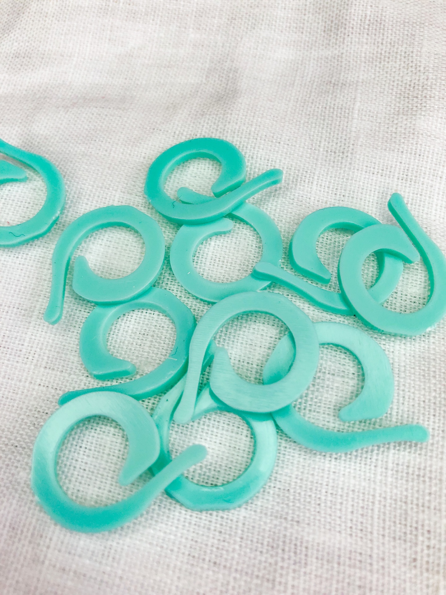 Clips de plástico turquesa em forma circular sobre tecido branco