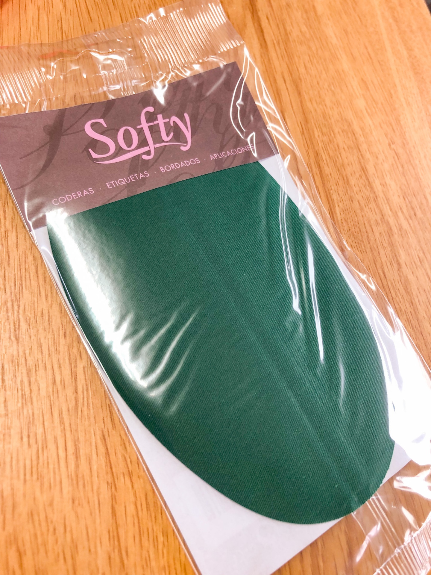 Produto têxtil verde escuro em embalagem com etiqueta Softy