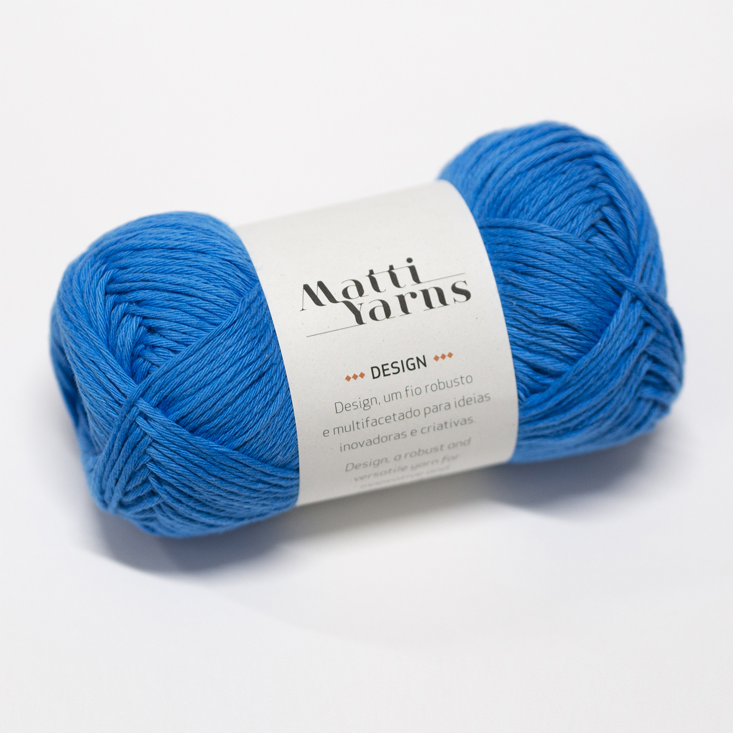 Novelo de lã azul Matti Yarns com etiqueta branca em fundo branco