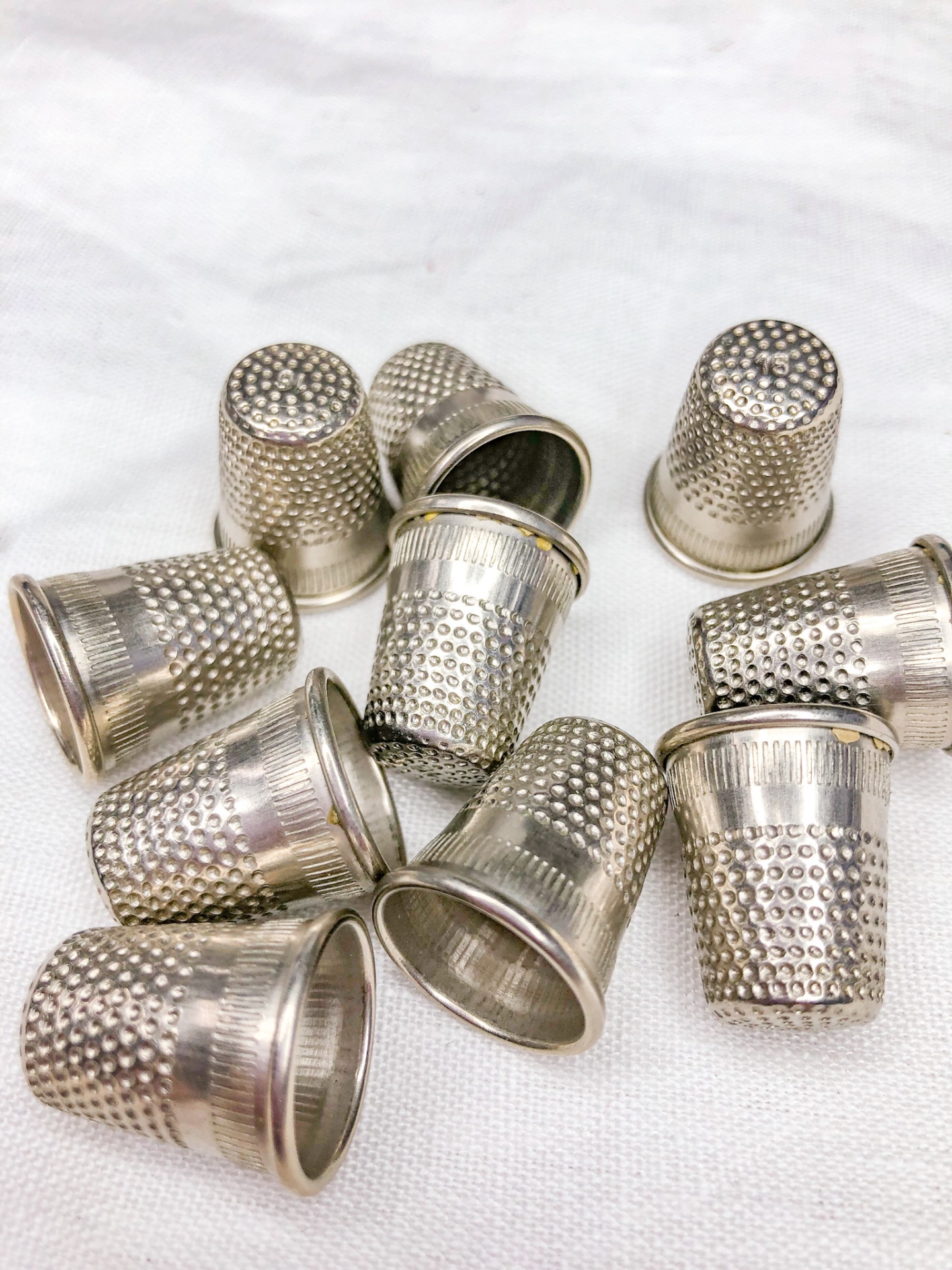 Dedais metálicos prateados texturizados sobre tecido branco