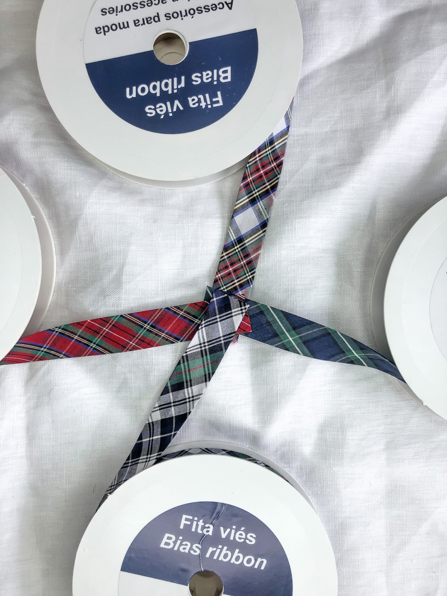 rolos de fita viés xadrez colorida sobre pano branco