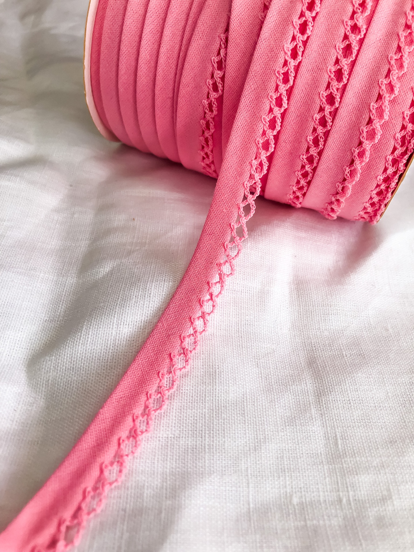 Rolo de fita têxtil rosa com bordado delicado